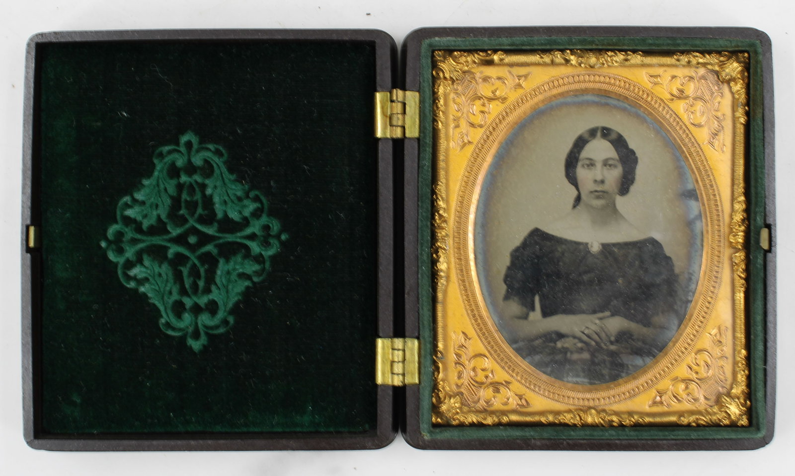 Ambrotype of a Woman in Plaid: Exception ambrotype of a woman in plaid. Case, lining and photo in excellent condition, quarter plate size. Gutta percha case with beautiful filigree. Approximately 1855-1865. Size: 3.75"T x 3.25"W x