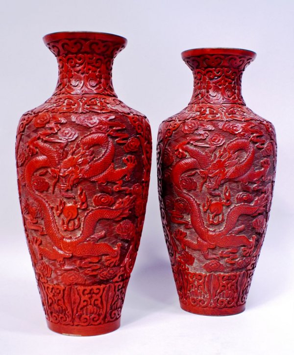 Pair of Chinese Cinnabar Dragon Vases: A matched pair of Chinese cinnabar baluster-form mantle vases, each 15 3/4"h, deeply carved on front and reverse with fiersome Chinese dragons.