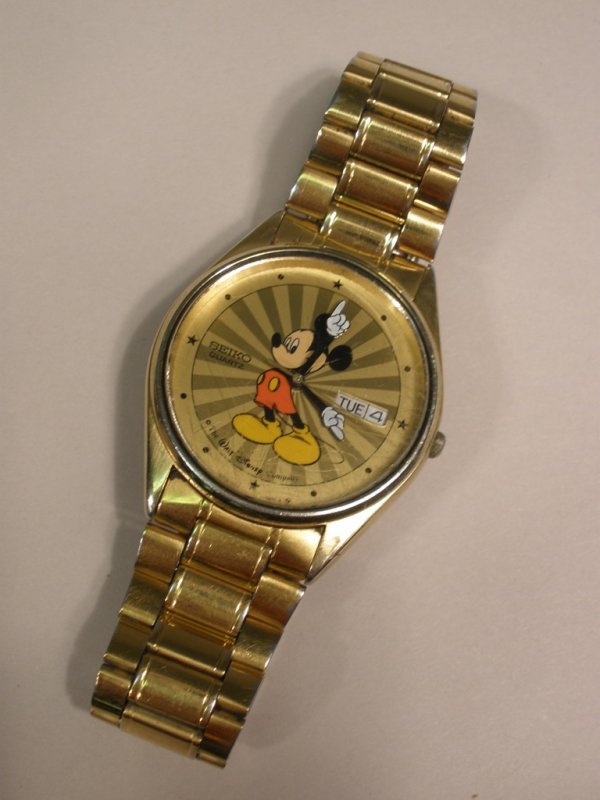 Vintage Seiko Quartz Men's Mickey Mouse Watch: a Vintage Seiko Quartz Men's Mickey Mouse Watch with starbrust dial and Seiko gold tone watch band, currently not running, scratches to bezel.