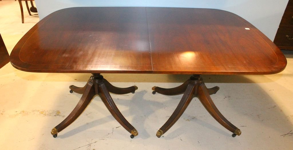 Two Pedestal Duncan Phyfe Dining Table: Elegant Baker two pedestal Duncan Phyfe dining table with string inlay, banding, and brass paw feet. Has three leaves; 68" w., 48" d., 29" h. ; leaves, 17 1/2" w. each