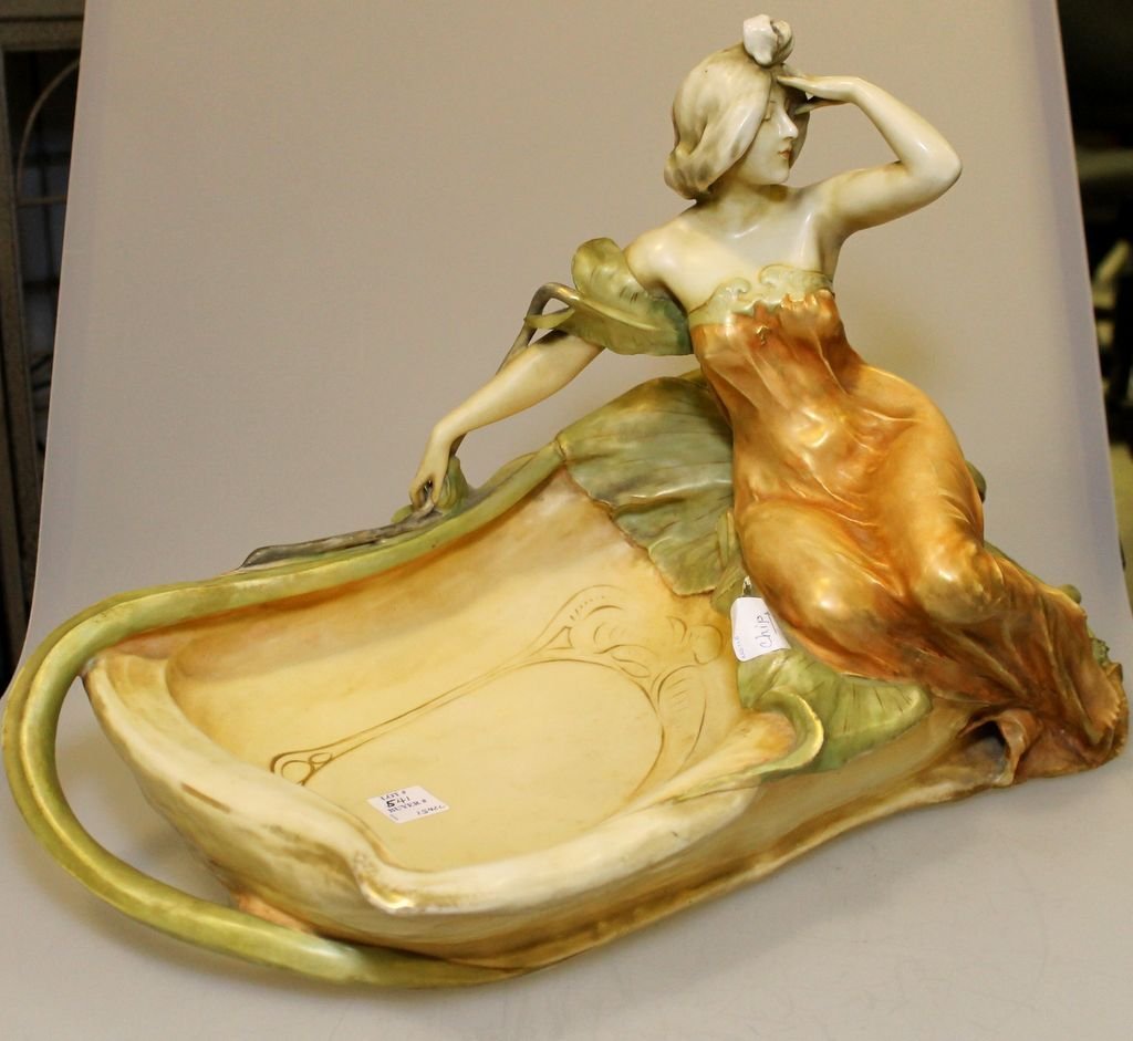 Art Nouveau Porcelain Centerpiece by Amphora: Unusual Art Nouveau maiden with lily centerpiece. Marked in Red Amphora, Turn Teplitz, Bohemia R st K, made in Austria; small chip on leaf; 19" w., 14" h.