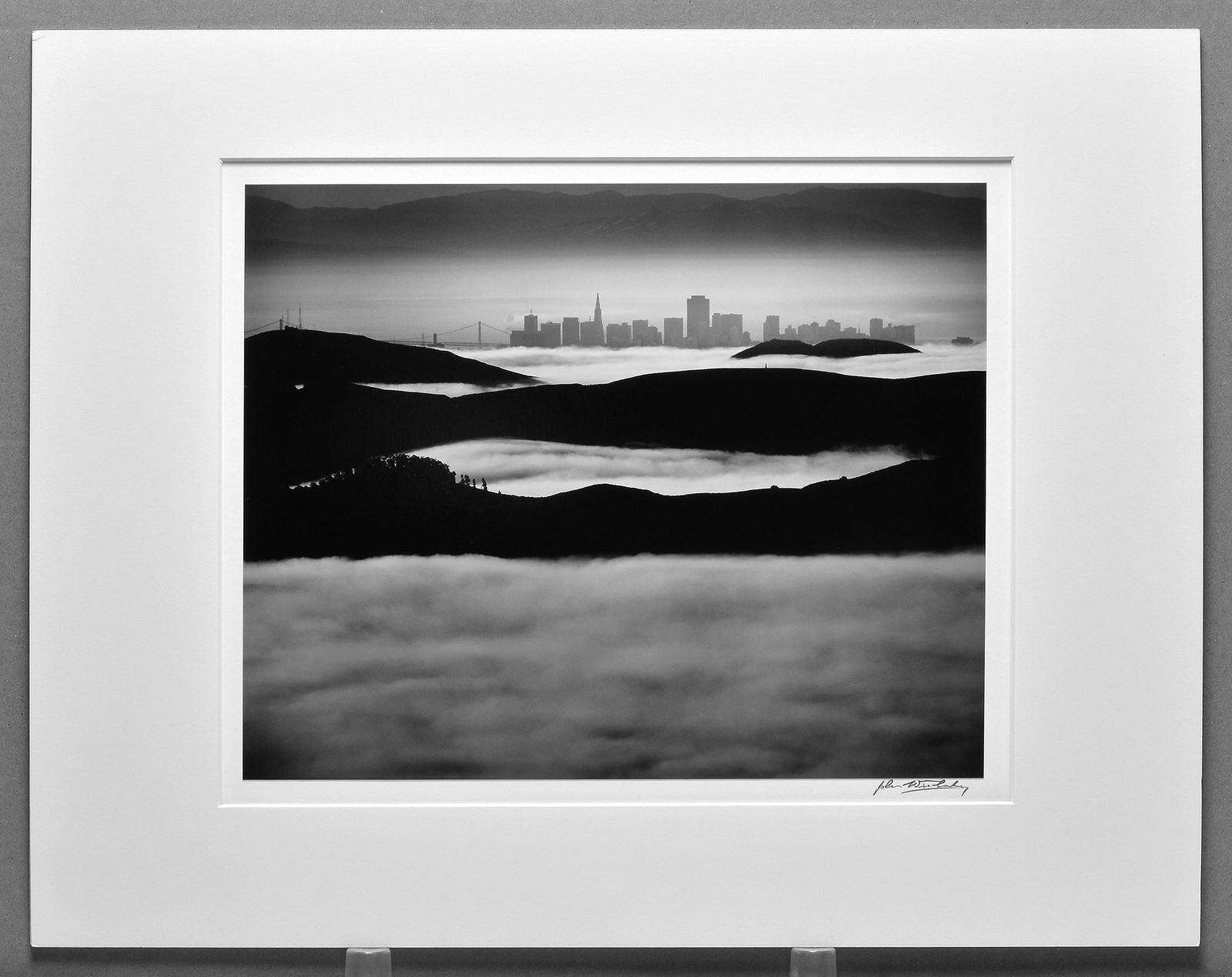 John Wimberley (1944 -) Signed 1977 San Francisco from Mount Tam 10.5"x12.5" Photograph: Taken in 1977, printed in 2018 Gelatin silver photograph Signed under the image, stamped and titled on the back Mounted/matted to 16"x20" museum board John Wimberley, a master of the darkroom, stopped