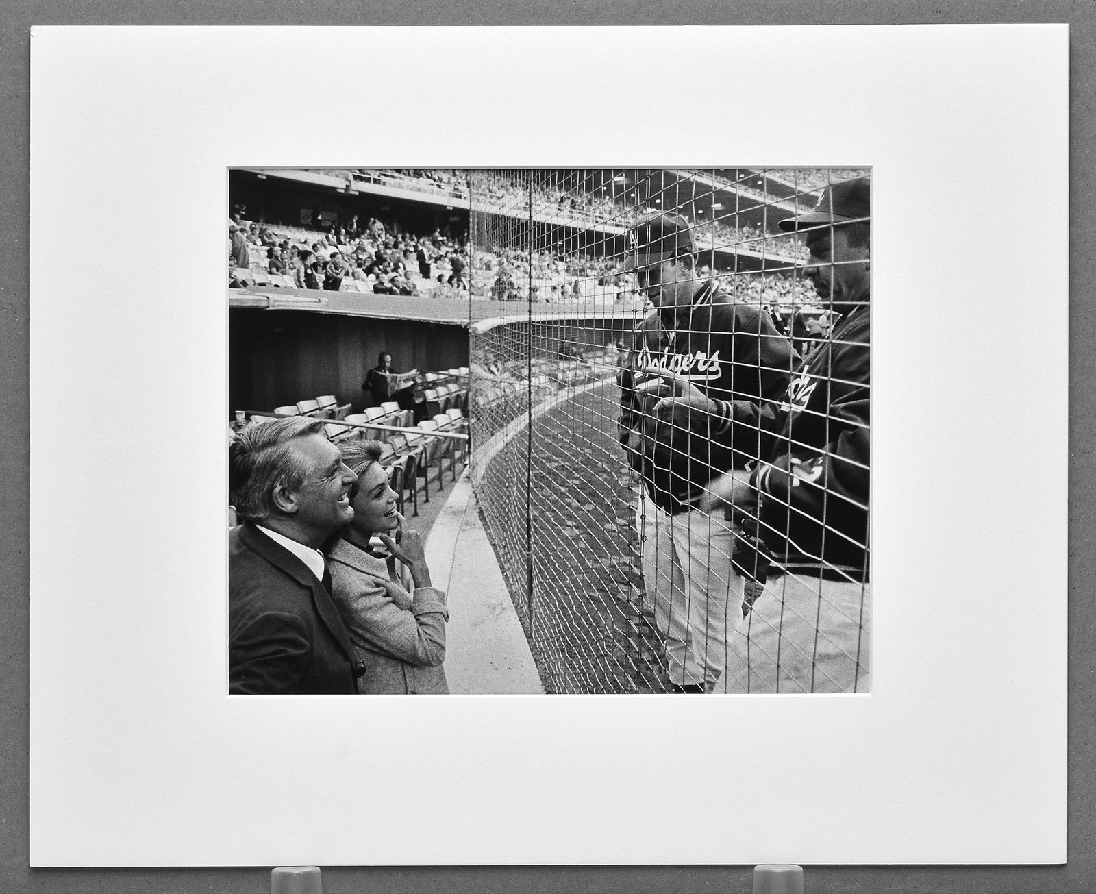 Philippe Halsman (1906-1979) Cary Grant & Dyan Cannon L.A. Dodgers, 1966 Published Photograph 8"x10": A scarce vintage gelatin silver press photograph by Philippe Halsman capturing Cary Grant and his wife, actress Dyan Cannon, with members of the Los Angeles Dodgers before a game in 1966. This candid 
