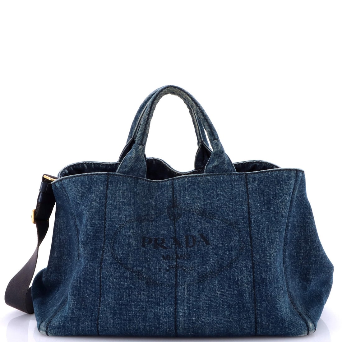 Large Prada Canapa Tote Denim: Large Prada Canapa Tote Denim Large Prada Canapa Tote made of blue denim, measuring 10" in height, 15" in width, with a handle drop of 7"; in good condition with notable wear and interior scuffs. Item