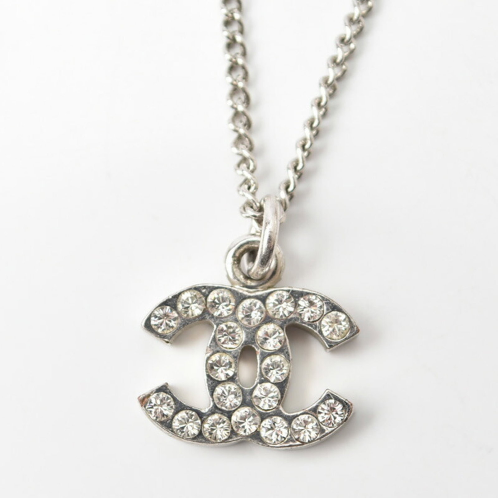 Chanel Rhinestone Metal: Chanel Rhinestone Metal This Chanel pendant necklace made of metal and rhinestones is in very good condition, featuring a 42 cm neck circumference and a pendant size of 11 x 14 mm. Item Specifics: Bra