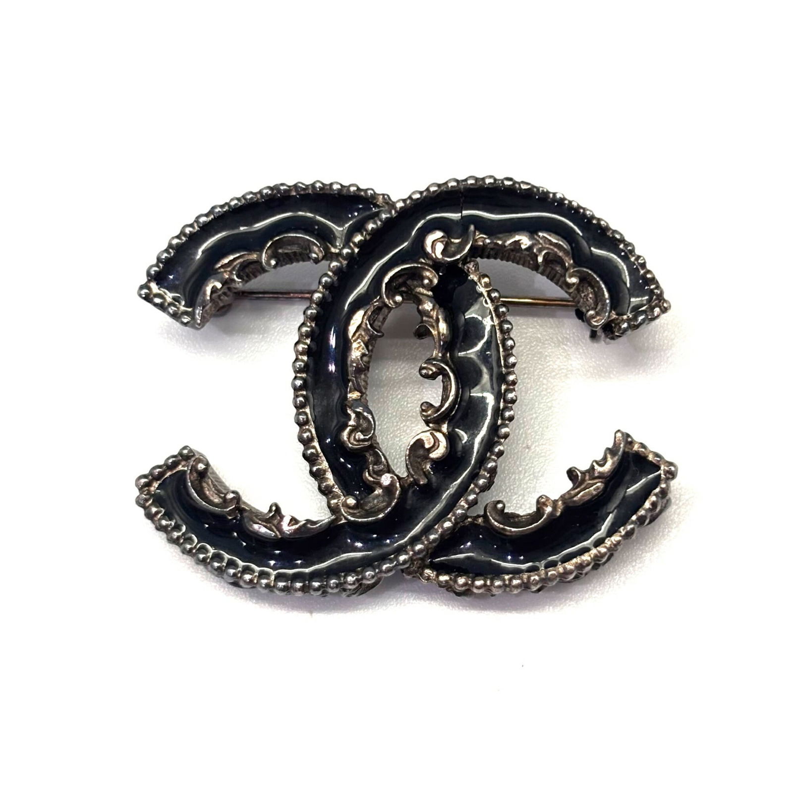 Enamel Chanel Brooch: Enamel Chanel Brooch This listing features Enamel Chanel Brooch. Item specifics are provided below. Item Specifics: Brand: Chanel Type: Brooch Gender: Women Material: Enamel Finish: Gold Plated