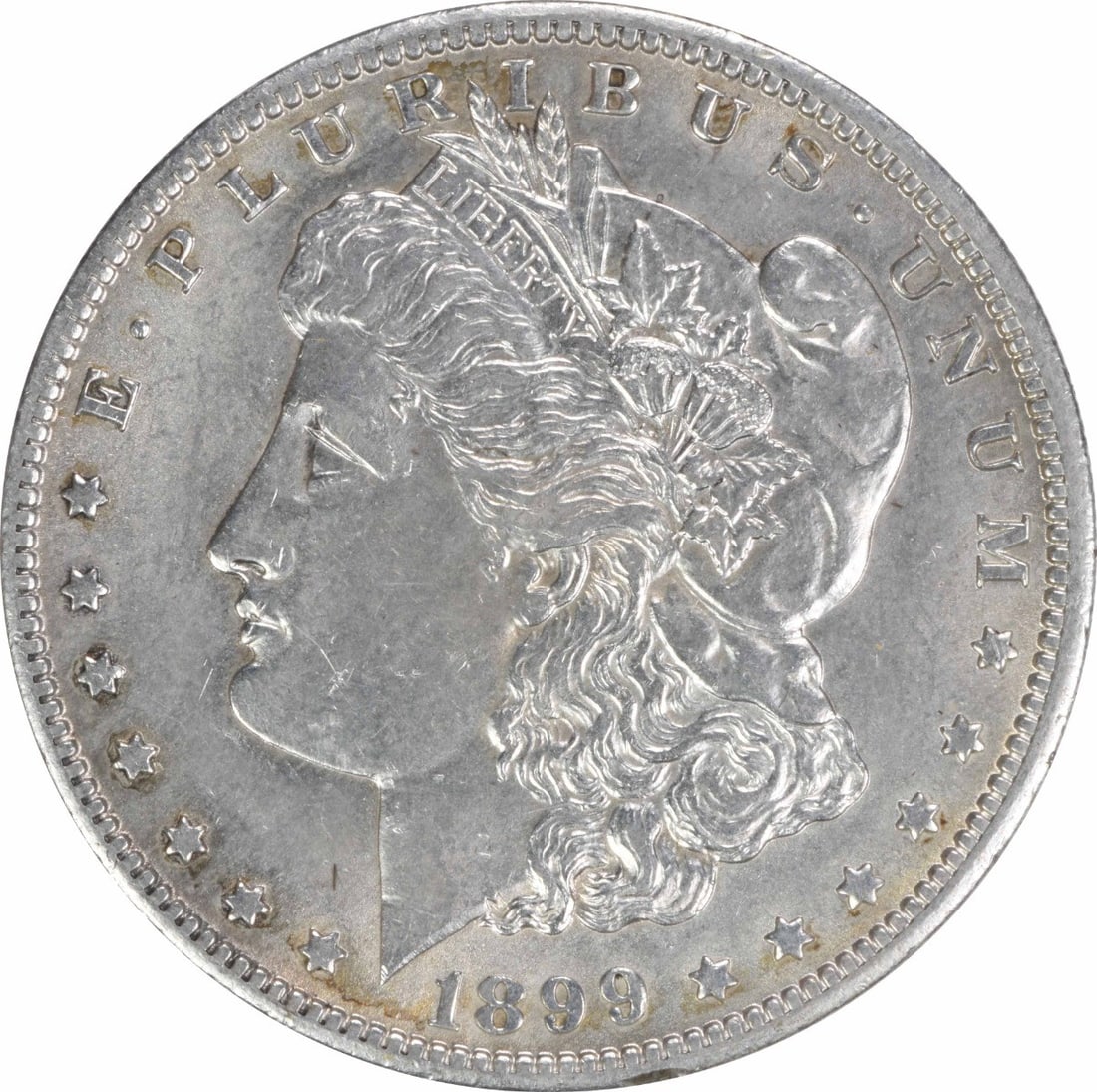 1899-O Morgan Silver Dollar - AU Uncertified: 1899-O Morgan Silver Dollar - AU Uncertified Experience the charm of the 1899-O Morgan Silver Dollar, a rare and highly sought-after coin from the iconic George T. Morgan design series. With its strik