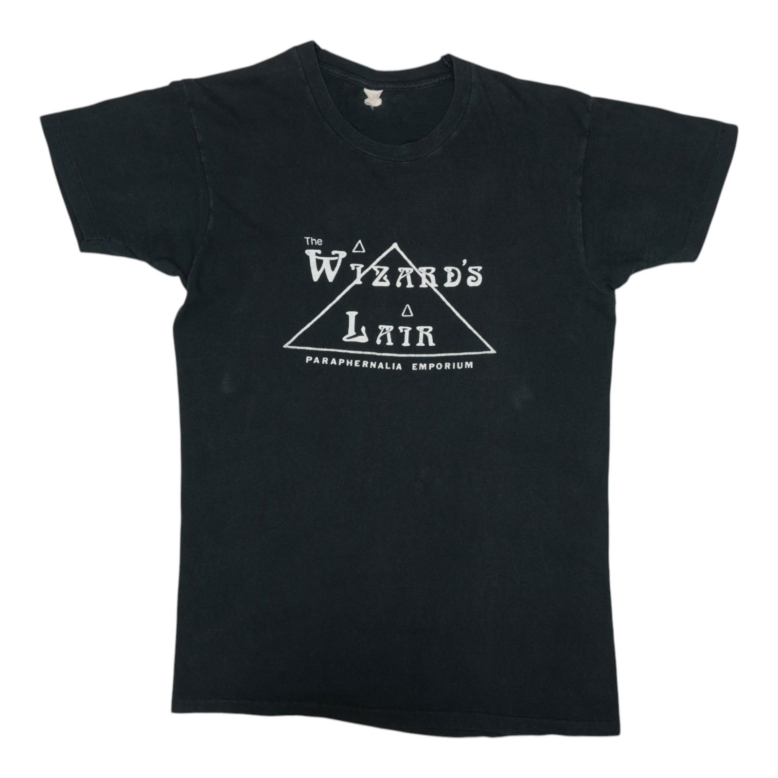 The Wizard's Lair 1970s Paraphernalia Shirt: The Wizard's Lair 1970s Paraphernalia Shirt Get ready to conjure up some 1970s magic with this authentic vintage The Wizard's Lair Paraphernalia Emporium shirt. Made from high-quality 100% cotton,