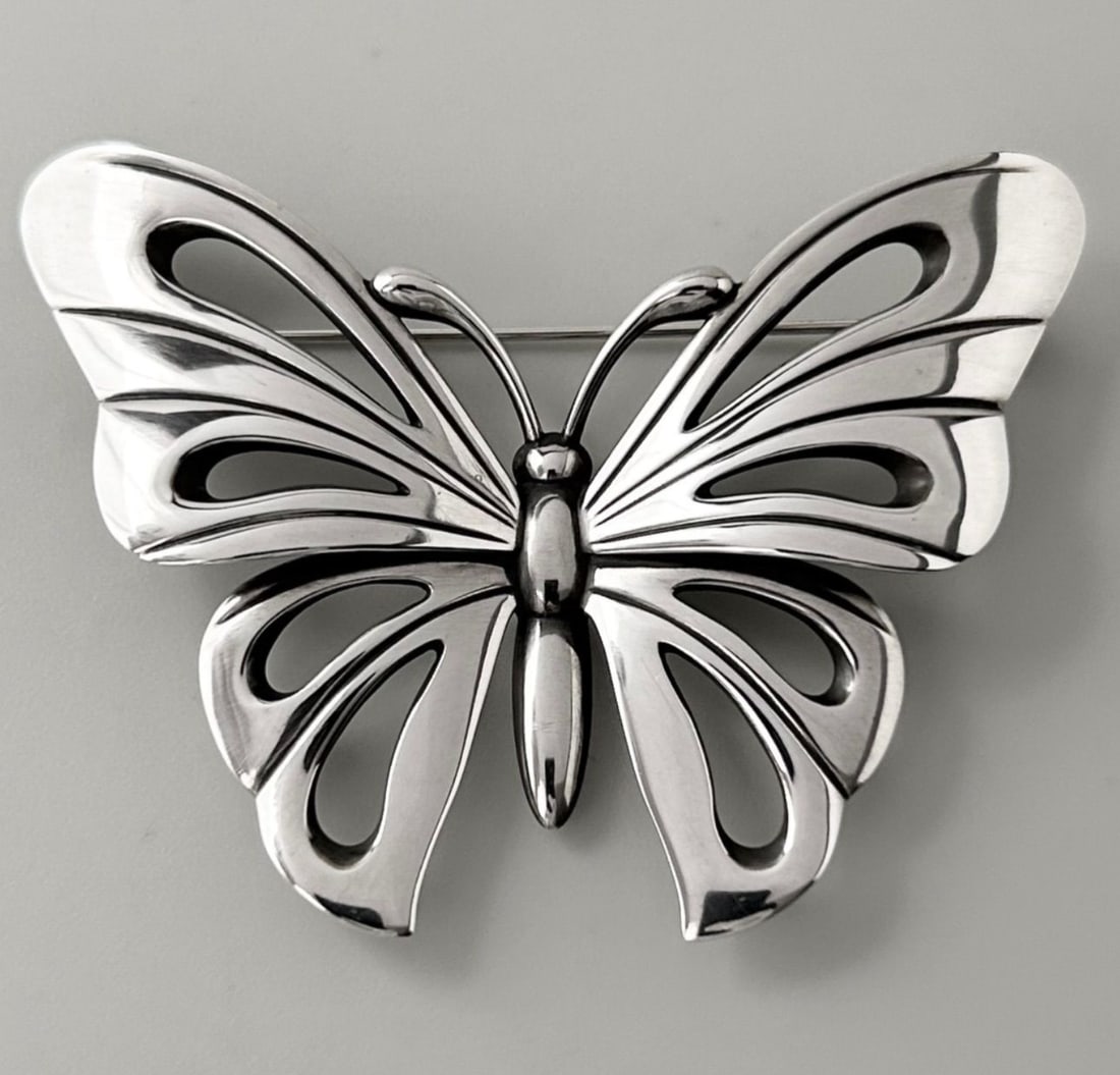 Georg Jensen No.563 Butterfly Pin Brooch in Sterling Silver: Georg Jensen No.563 Butterfly Pin Brooch in Sterling Silver The Georg Jensen No.563 Butterfly Pin Brooch is a stunning sterling silver piece that showcases the brand's signature minimalist elegance. W