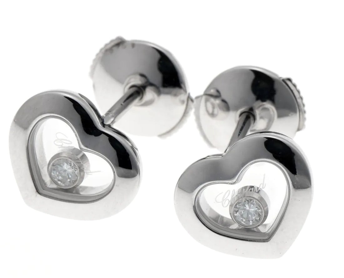 Chopard Happy Diamonds Floating Icon Heart 18k White Gold Stud Earrings (Germany): Chopard Happy Diamonds Floating Icon Heart 18k White Gold Stud Earrings (Germany) Elevate your style with these stunning 18k white gold stud earrings, adorned with two sparkling round diamonds and a d