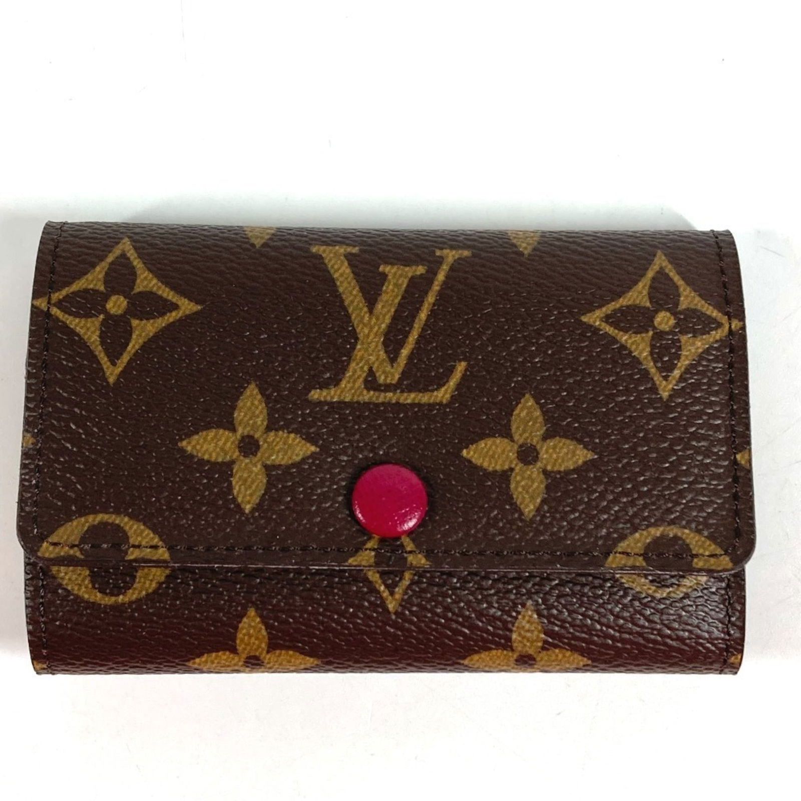 Keycase Louis Vuitton: Keycase Louis Vuitton A stylish and practical accessory, this Louis Vuitton keycase is a timeless addition to any bag collection. With its rich brown color and vibrant fuchsia accents, it adds a pop