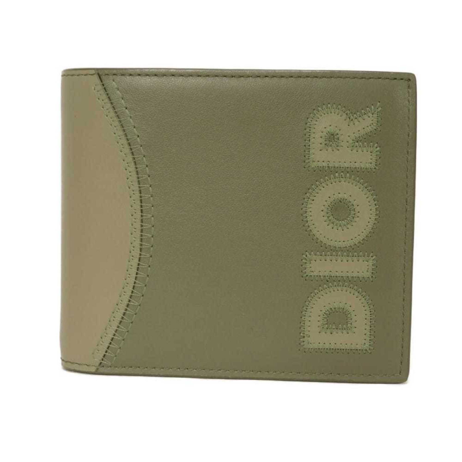 Christian Dior Bi-Fold Leather Wallet: Christian Dior Bi-Fold Leather Wallet A timeless piece from the iconic Christian Dior brand, this bi-fold leather wallet boasts a classic khaki color and premium calfskin material that exudes
