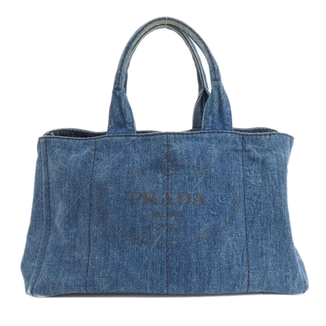 Prada Canapa Tote Bag in Denim: Prada Canapa Tote Bag in Denim The Prada Canapa Tote Bag in Denim is a timeless and stylish accessory that exudes Italian elegance. Made from high-quality denim, this navy tote bag boasts a classic