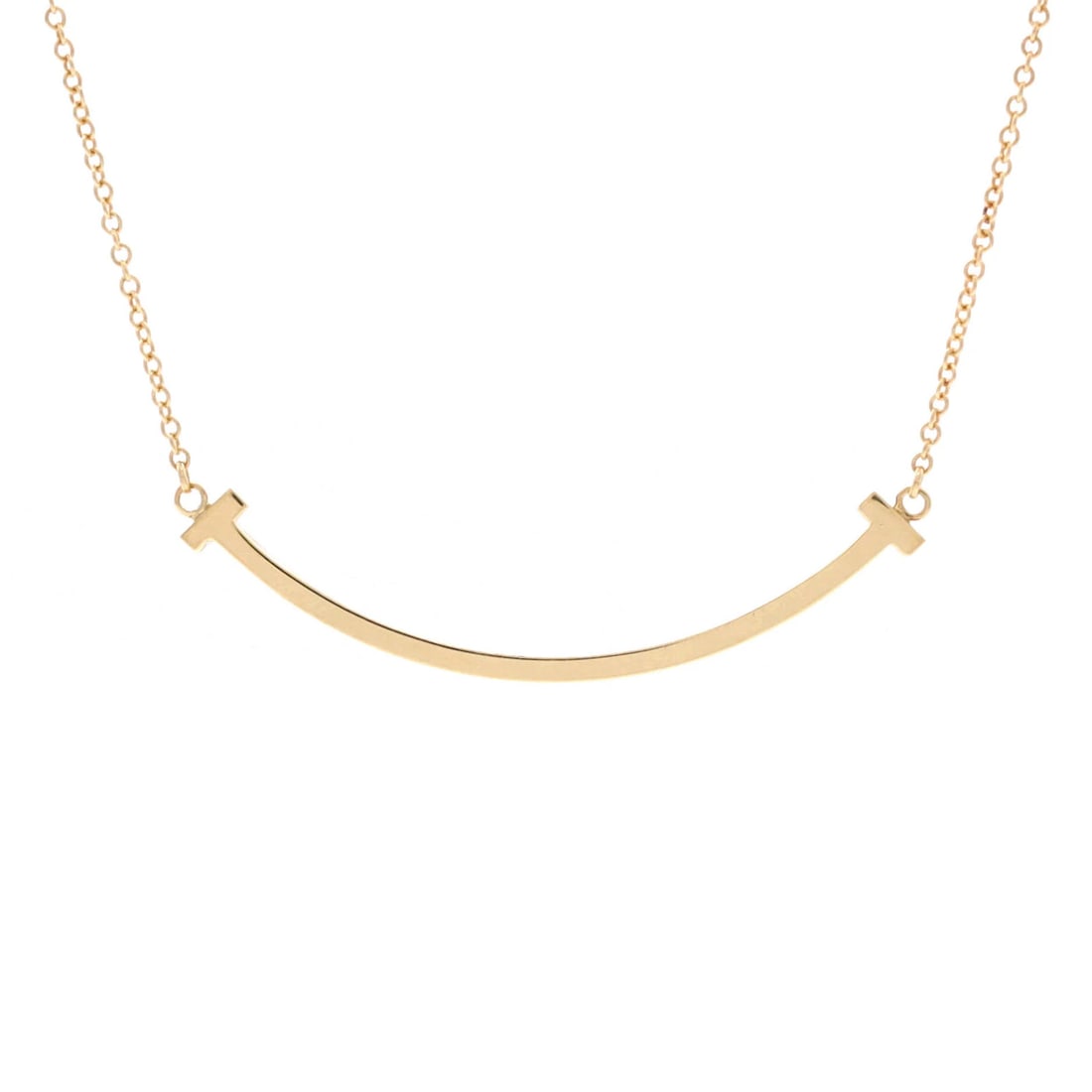 Tiffany & Co. T Smile Pendant Necklace in 18K Yellow Gold: Tiffany & Co. T Smile Pendant Necklace in 18K Yellow Gold A timeless Tiffany & Co. classic, the T Smile Pendant Necklace in 18K yellow gold is a masterclass in understated elegance. This exquisite