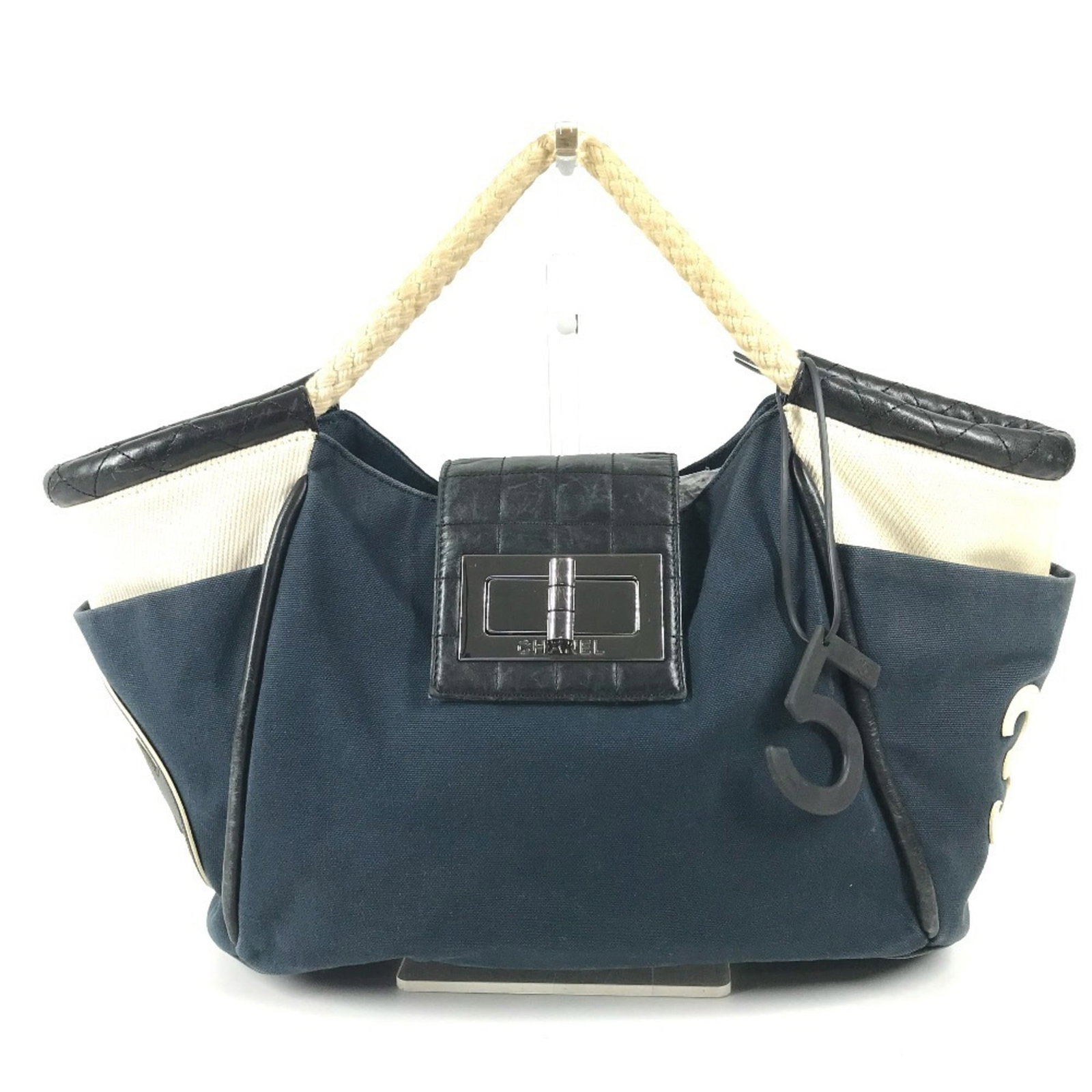 Chanel Tote Bag in Canvas and Leather: Chanel Tote Bag in Canvas and Leather A pre-owned Chanel tote bag in navy and white, crafted from high-quality canvas and leather, makes for a stylish and timeless accessory. With its classic design