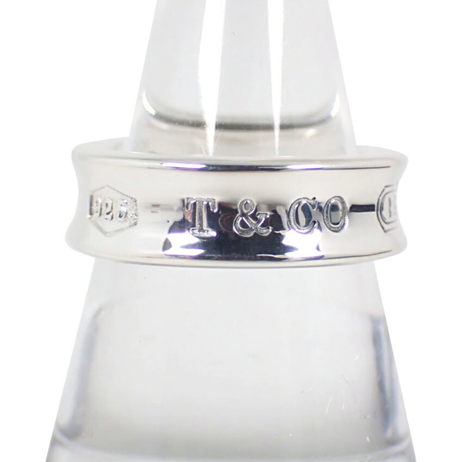 Sterling Silver 925 Tiffany Band Ring: Sterling Silver 925 Tiffany Band Ring Elevate your everyday style with this stunning sterling silver band ring, crafted from 925 solid silver and bearing the iconic Tiffany mark. With its sleek design