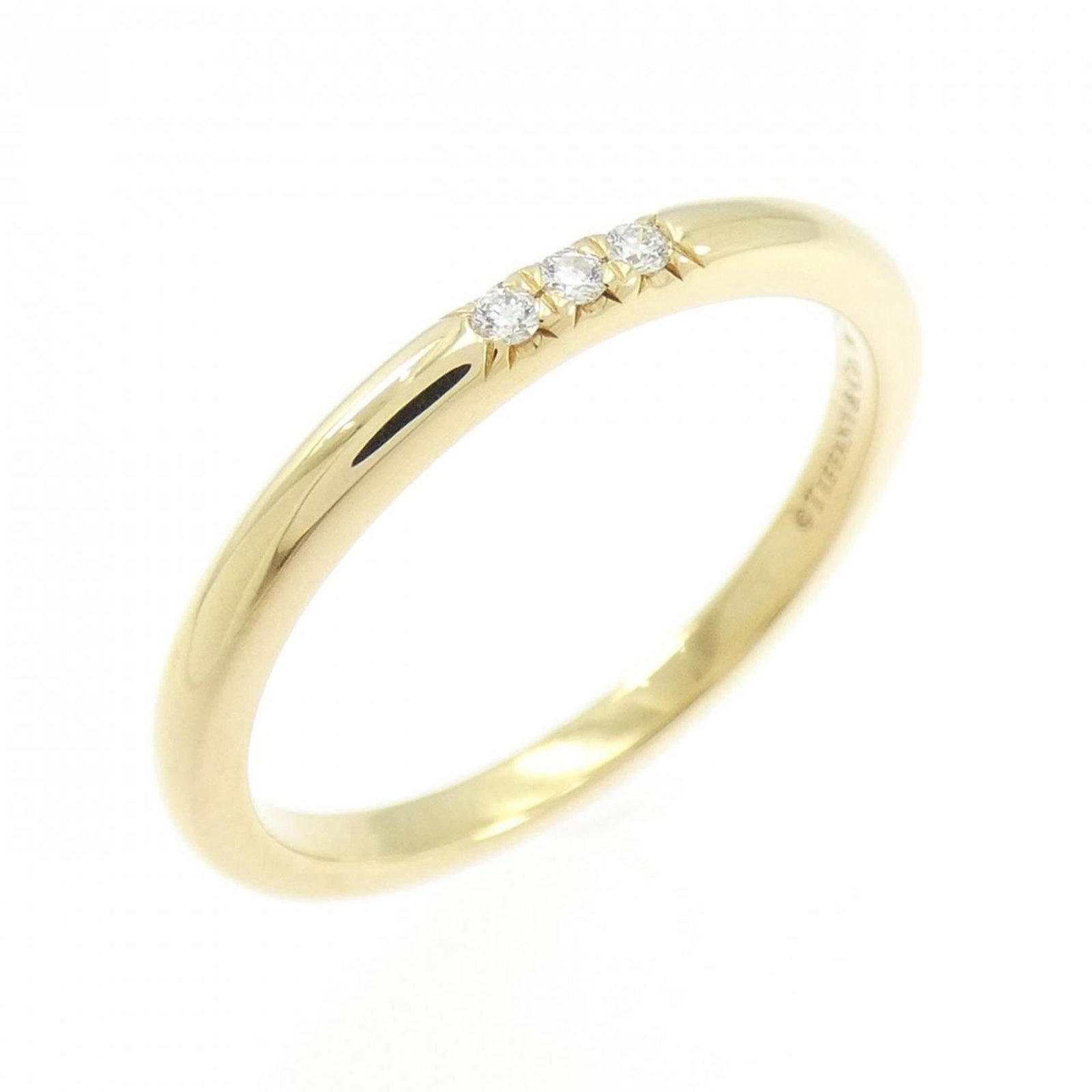 (18K) Tiffany Band Ring Yellow Gold: (18K) Tiffany Band Ring Yellow Gold A stunning 18K yellow gold band ring from Tiffany, adorned with a sparkling diamond, adds a touch of elegance to any outfit. With its slender 1.9mm width and comfor
