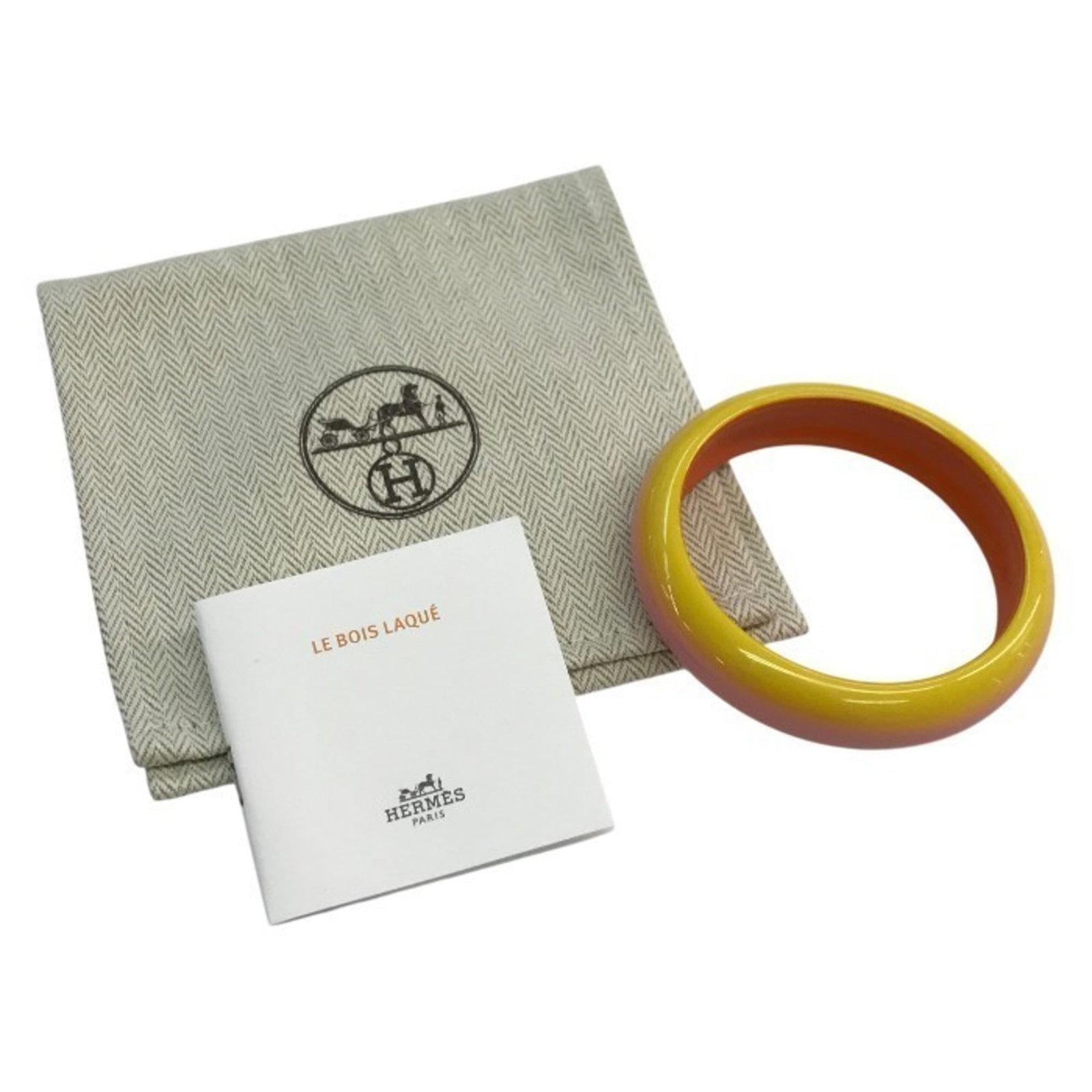 Hermes Bangle with Lacquer and Wood: Hermes Bangle with Lacquer and Wood A stunning Hermes bangle, crafted from vibrant lacquer and rich wood, adds a pop of color to any outfit with its unique pink-orange, yellow hues. With its elegant 7