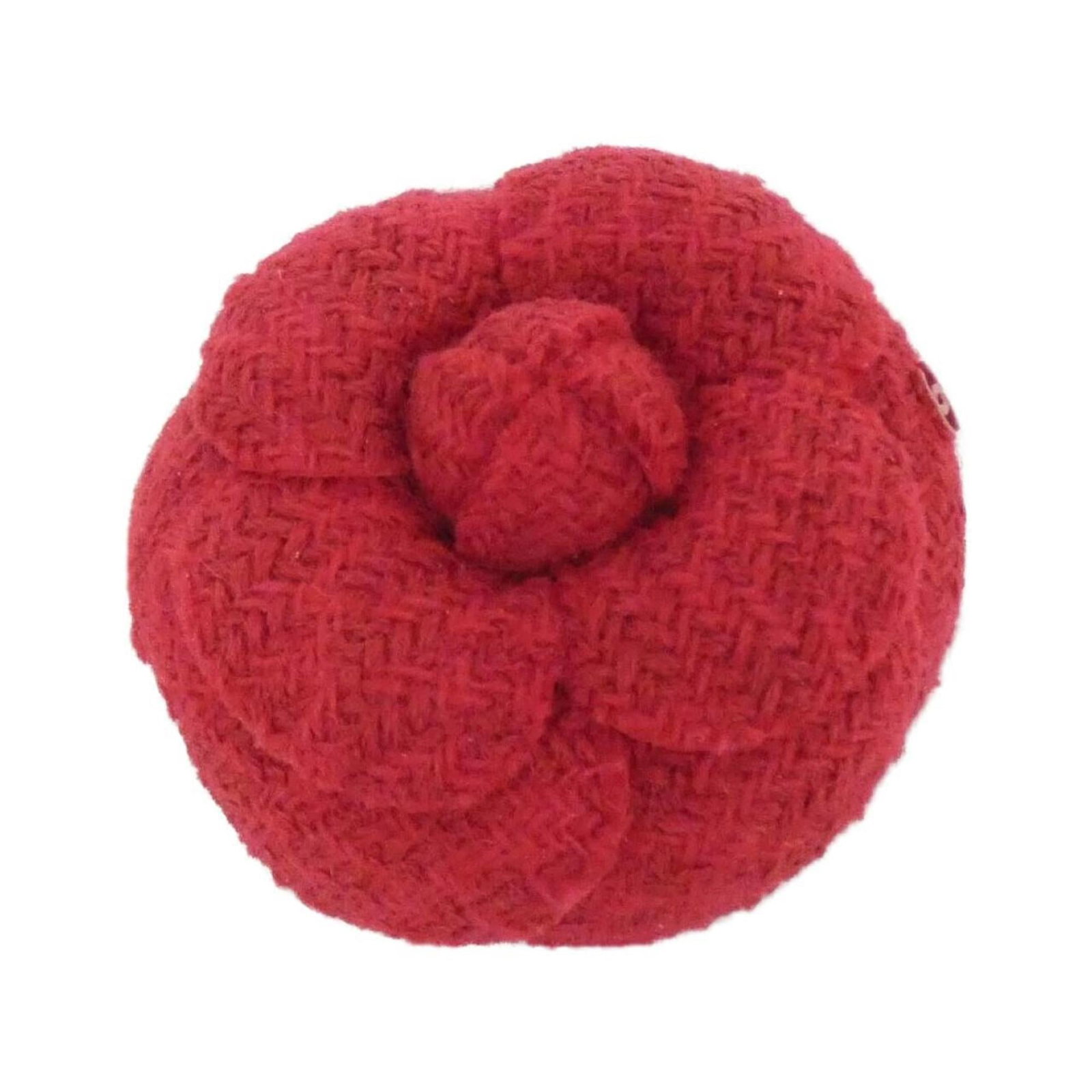 Corsage Chanel: Corsage Chanel A stunning Chanel corsage in bold red, adorned with intricate silver details, adds a touch of timeless elegance to any outfit. Its compact size and delicate design make it perfect for a