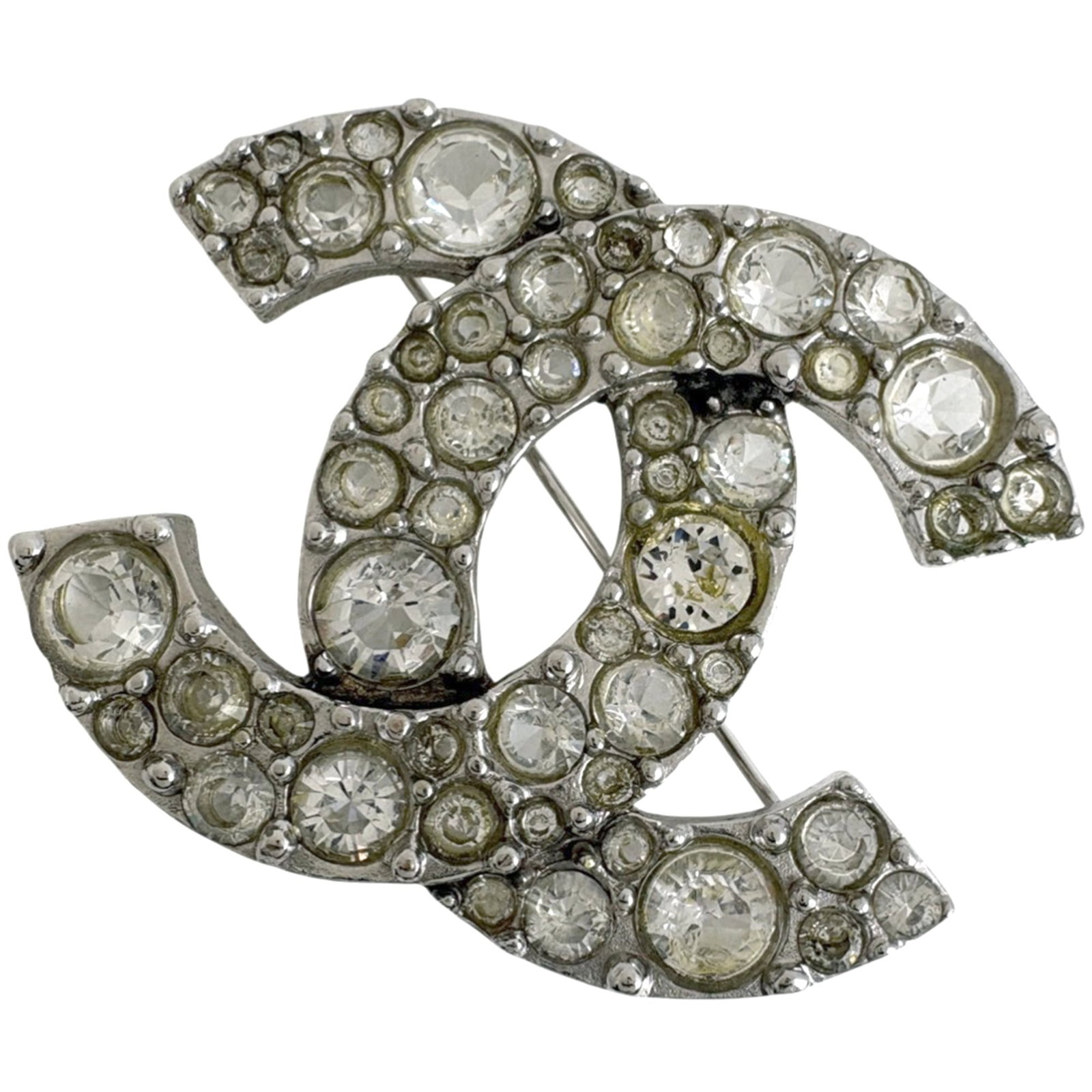 Chanel Brooch in Metal: Chanel Brooch in Metal A sleek and sophisticated silver Chanel brooch, measuring 4.5cm x 3.5cm, adds a touch of timeless elegance to any outfit. With its classic design and durable metal construction,