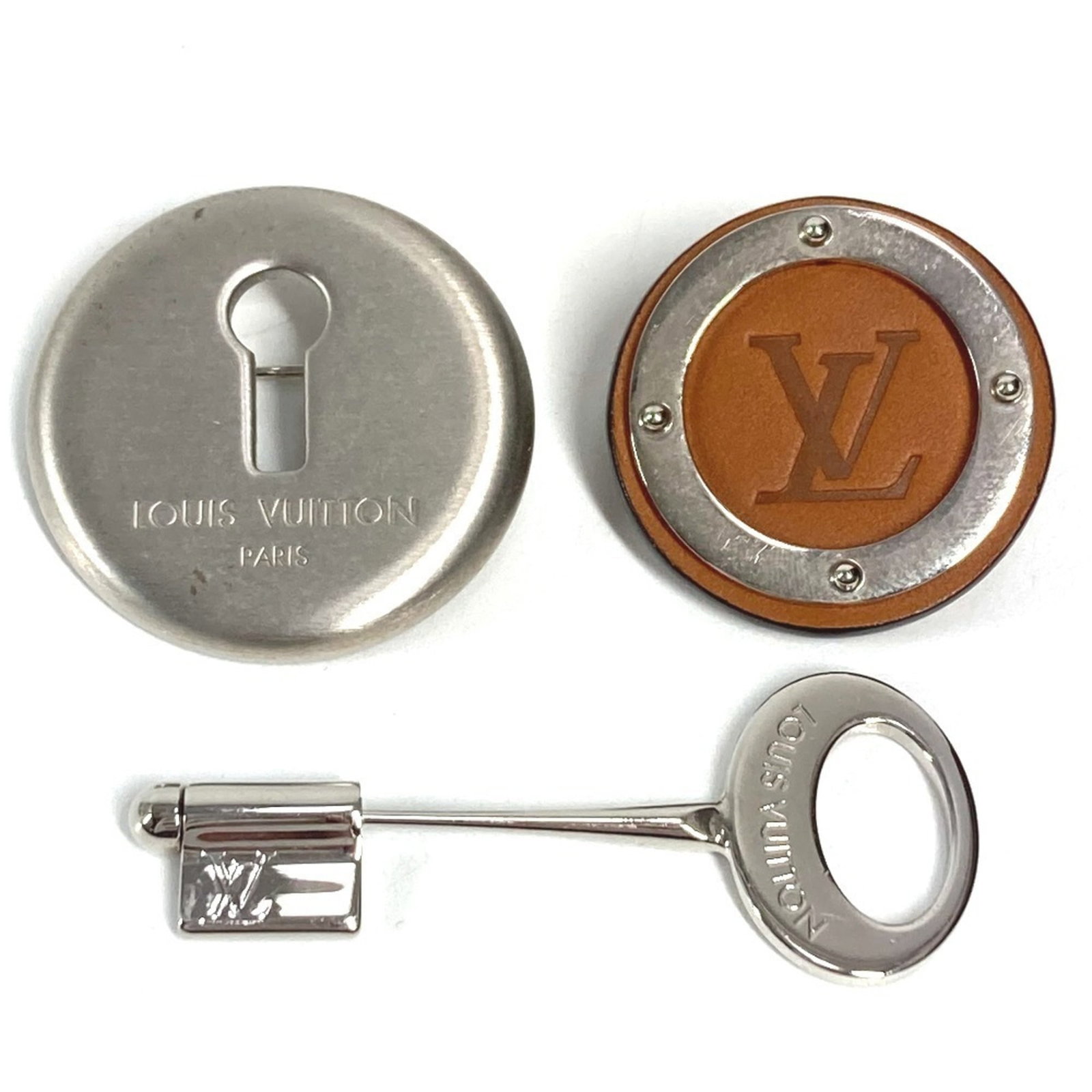 Louis Vuitton Metal Brooch: Louis Vuitton Metal Brooch A luxurious touch for any outfit, this Louis Vuitton metal brooch boasts the iconic brand's signature monogram pattern in elegant brown and silver tones. With its sleek meta