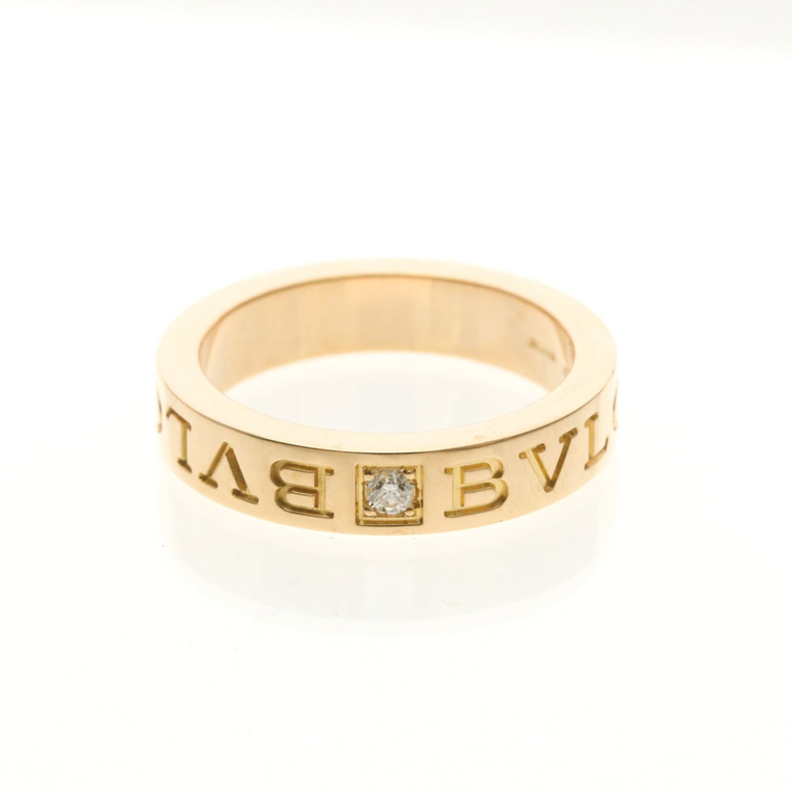 Pink Gold 18k Bvlgari Band Ring: Pink Gold 18k Bvlgari Band Ring Elevate your style with this stunning 18k pink gold Bvlgari band ring, adorned with a diamond that shines bright against the luxurious metal. The subtle pink hue and sl