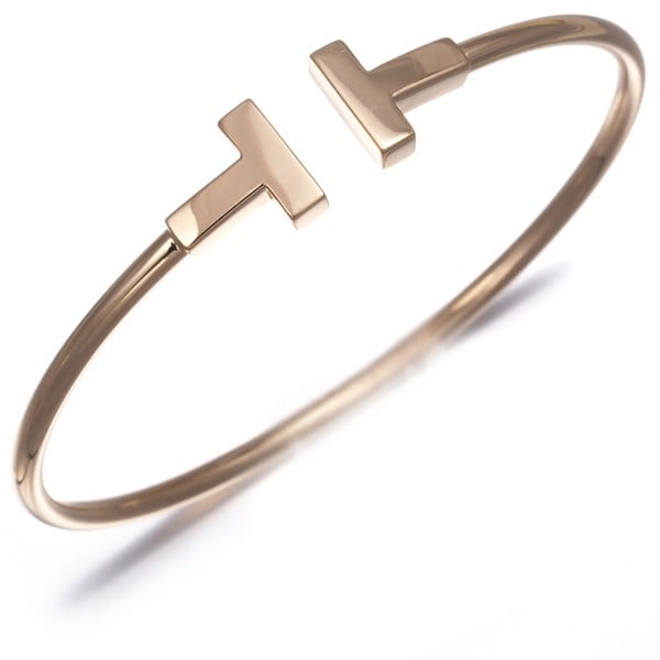 Tiffany & Co. 18k Rose Gold Tiffany T Wire Bangle: Tiffany & Co. 18k Rose Gold Tiffany T Wire Bangle Elevate your style with the timeless elegance of Tiffany & Co.'s 18k Rose Gold Tiffany T Wire Bangle, crafted from rich, high-karat metal and boasting