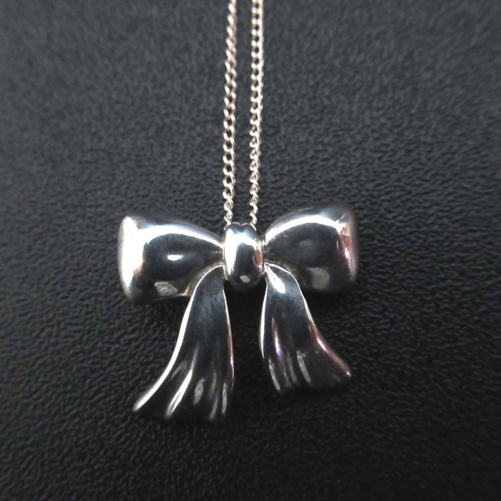 Tiffany & Co. 925SV Silver Women's Ribbon Necklace Pendant: Tiffany & Co. 925SV Silver Women's Ribbon Necklace Pendant Elegant and sophisticated, the Tiffany & Co. 925SV Silver Women's Ribbon Necklace Pendant is a timeless piece that exudes refinement. With it