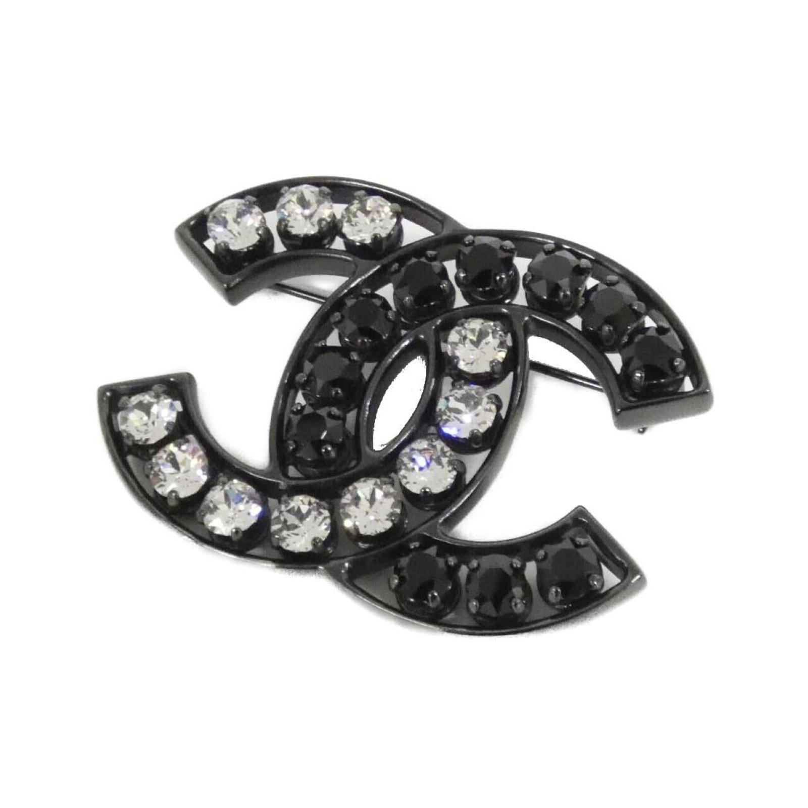 Chanel Brooch in Metal: Chanel Brooch in Metal A sleek and sophisticated Chanel brooch, crafted from metal with a striking black finish, adds a touch of timeless elegance to any outfit. Featuring a beautiful crystal stone, t