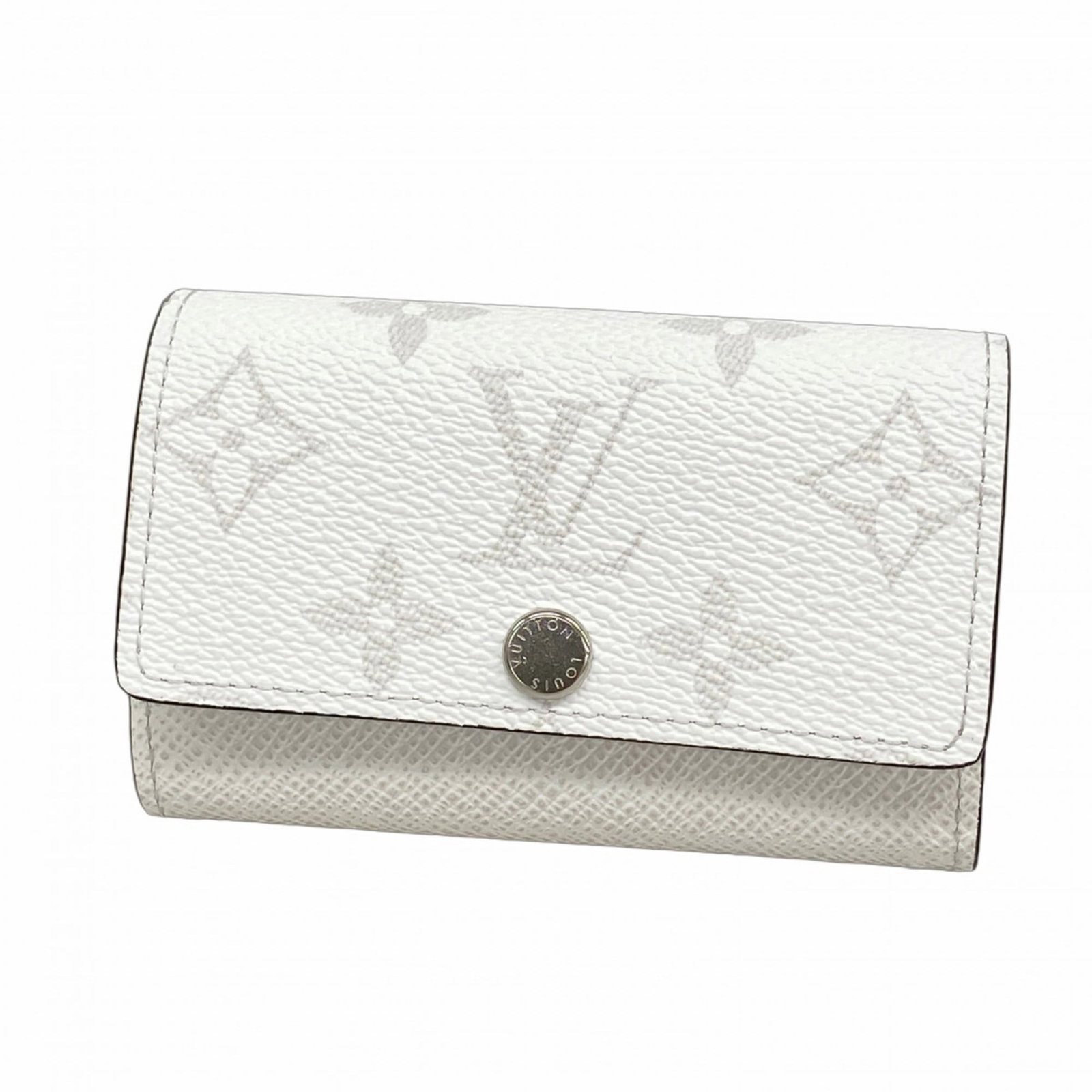 Keycase Louis Vuitton: Keycase Louis Vuitton A pristine Louis Vuitton keycase in white, bearing the hallmarks of classic luxury, with subtle signs of wear that only add to its timeless charm. Its clean lines and sleek desig