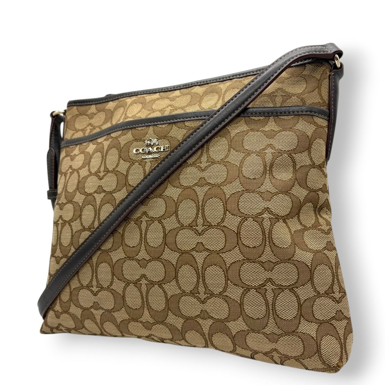 Canvas and Leather Coach Shoulder Bag: Canvas and Leather Coach Shoulder Bag A timeless Coach shoulder bag, crafted from luxurious canvas and supple leather in a beautiful beige and brown hue, boasts a classic design that exudes effortless