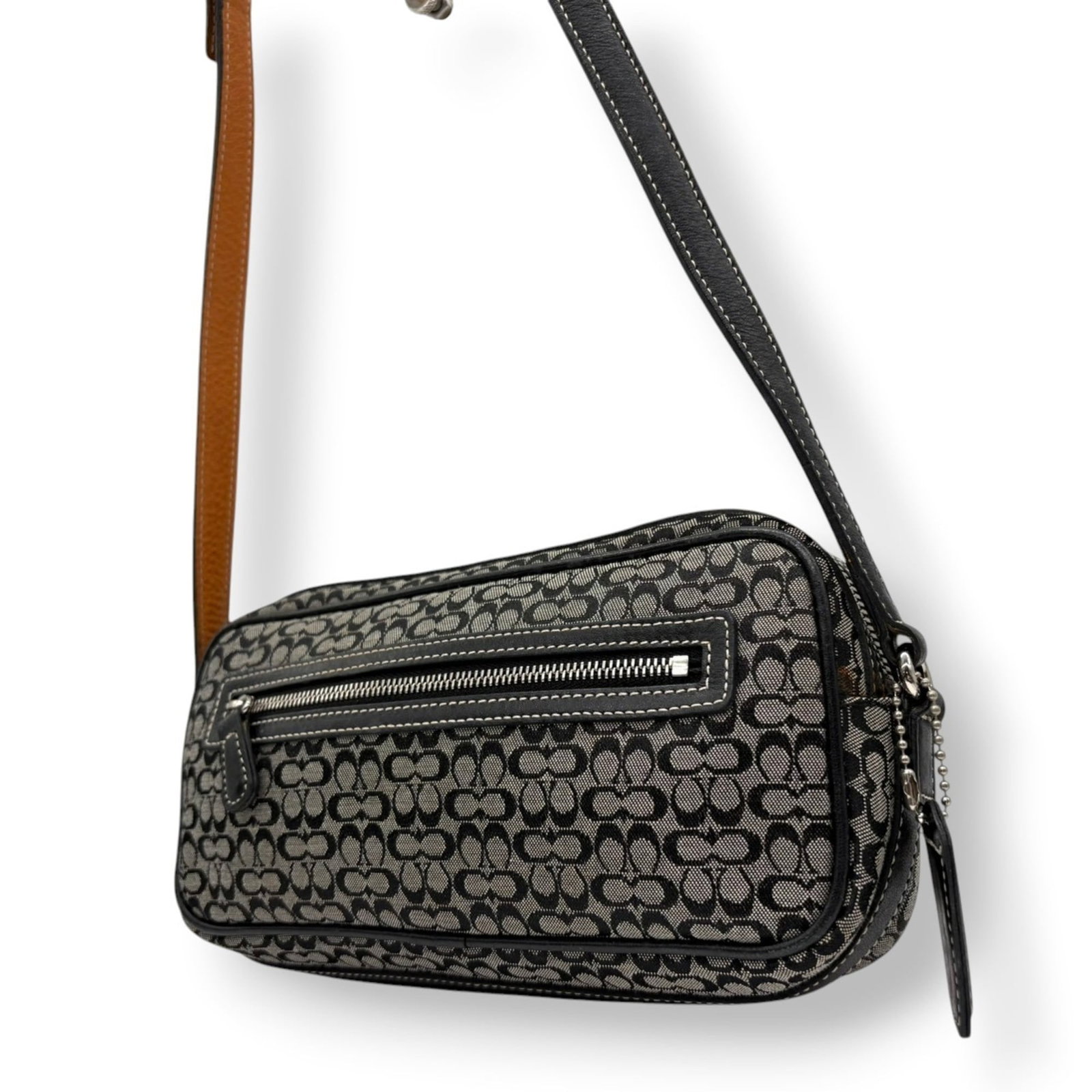 Canvas and Leather Coach Shoulder Bag: Canvas and Leather Coach Shoulder Bag Elevate your style with this pre-loved Coach shoulder bag, boasting a chic canvas and leather design in sleek black and gray hues. With its spacious interior and