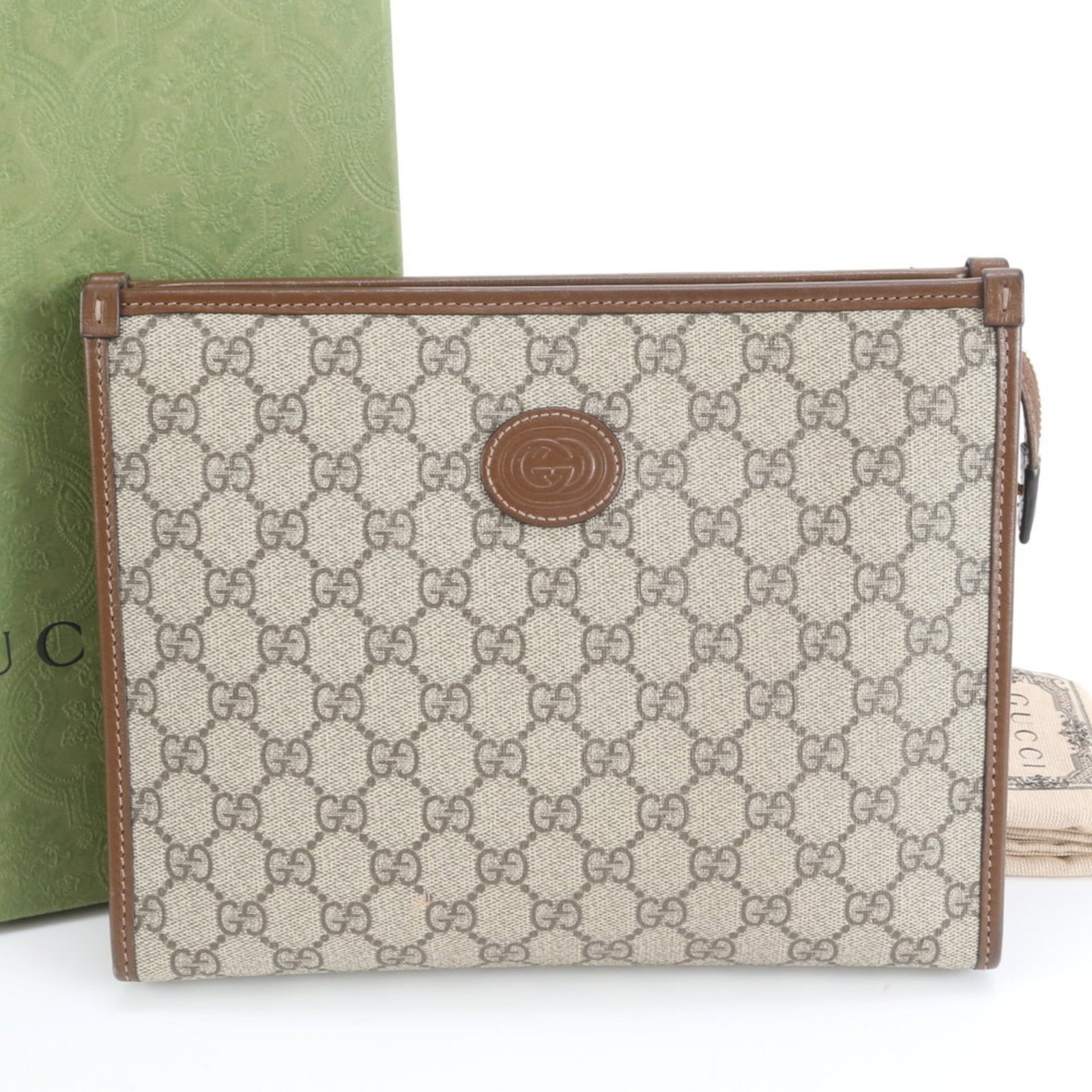 Gucci Clutch Bag in Leather and Coated Canvas: Gucci Clutch Bag in Leather and Coated Canvas A luxurious Gucci clutch bag in rich brown leather, paired with coated canvas accents, adds an effortless touch of sophistication to any outfit. With its