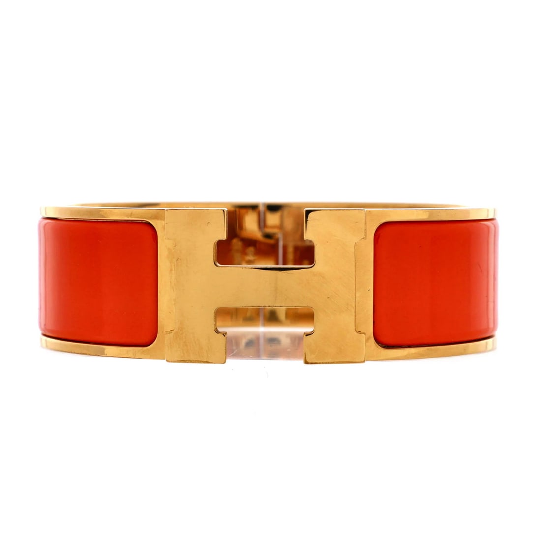 Hermes Clic Clac H Bracelet in Metal & Enamel, Wide: Hermes Clic Clac H Bracelet in Metal & Enamel, Wide A vibrant orange and gold Clic Clac H bracelet from the iconic French fashion house Hermes, boasting a wide exterior with enamel details that add a