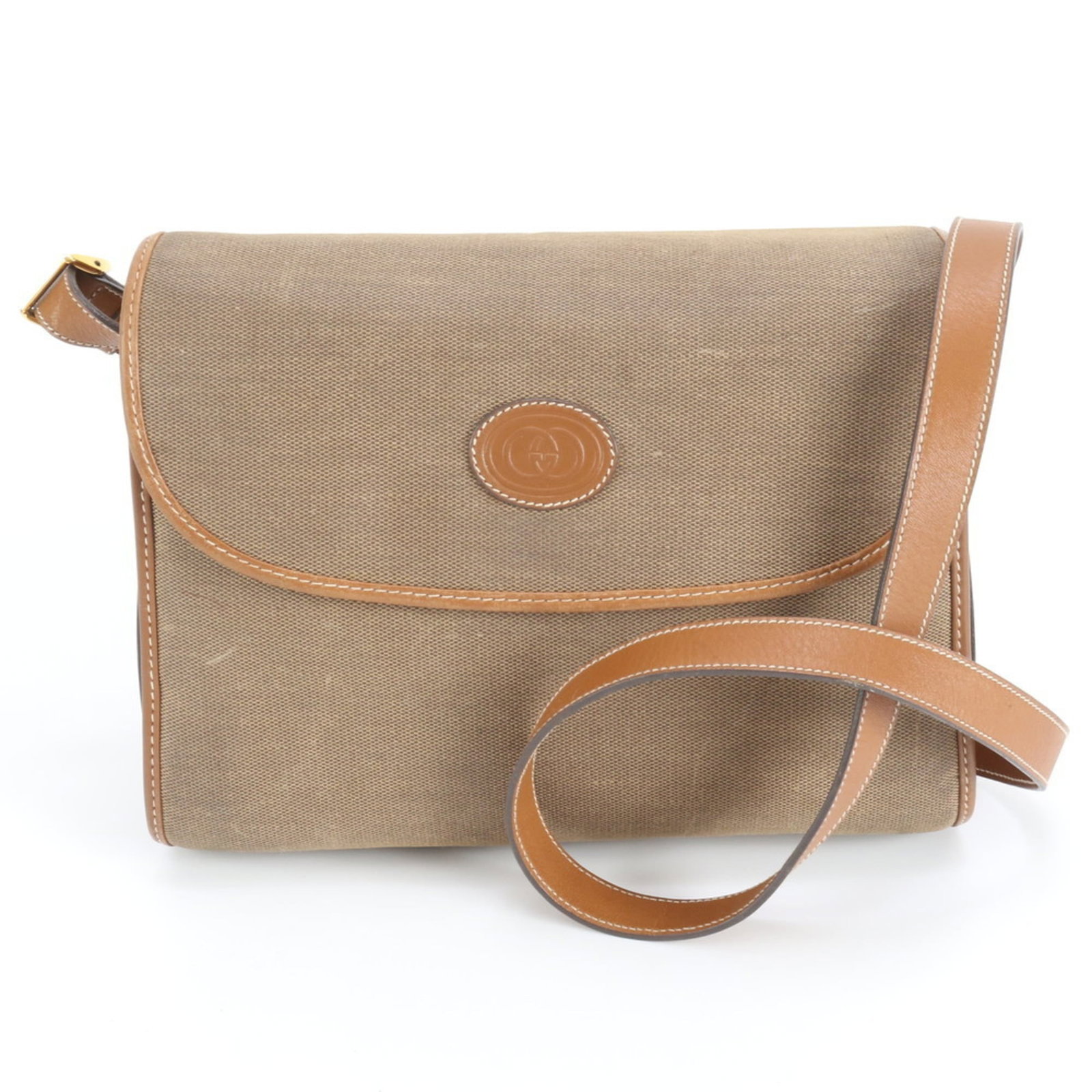 Gucci Canvas and Leather Shoulder Bag: Gucci Canvas and Leather Shoulder Bag A vintage Gucci canvas and leather shoulder bag in rich brown tones, boasting a timeless design that exudes classic elegance. With its sturdy canvas base, supple