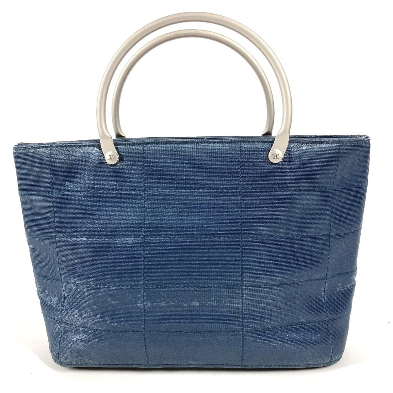 Chanel Tote Bag in Nylon Canvas: Chanel Tote Bag in Nylon Canvas A pre-owned Chanel tote bag in blue nylon canvas, perfect for adding an edgy touch to your everyday look. With its classic design and durable construction, this timeles
