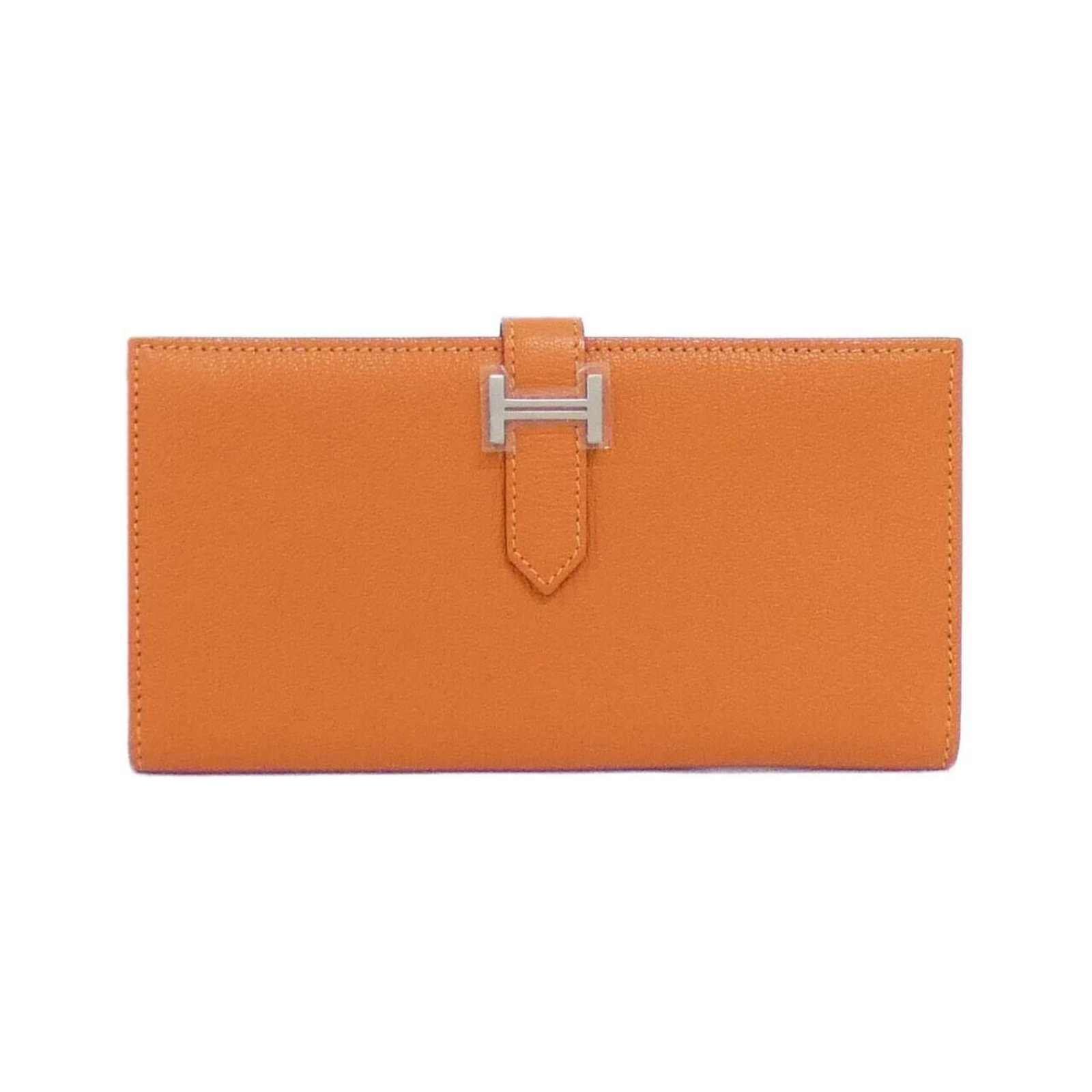 Hermes Bi-Fold Chevre Leather Wallet: Hermes Bi-Fold Chevre Leather Wallet A vibrant orange Herm?s bi-fold wallet, crafted from rich chevre leather, adds a pop of color to any outfit. With its classic design and durable construction, this