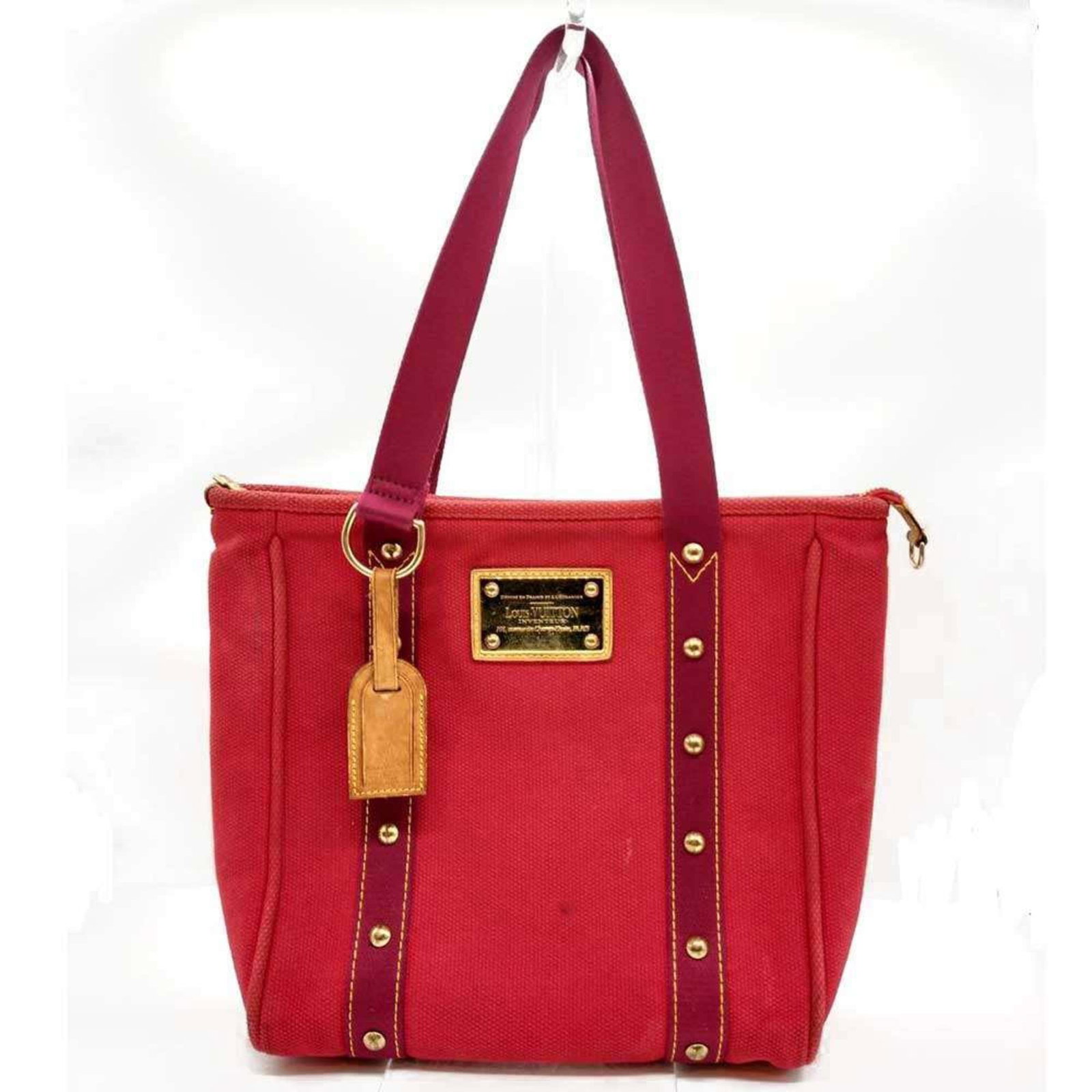 Louis Vuitton Canvas Tote Bag: Louis Vuitton Canvas Tote Bag Experience the timeless elegance of Louis Vuitton with this classic canvas tote bag, boasting a chic rose hue and sturdy zipper closure. With its spacious interior and