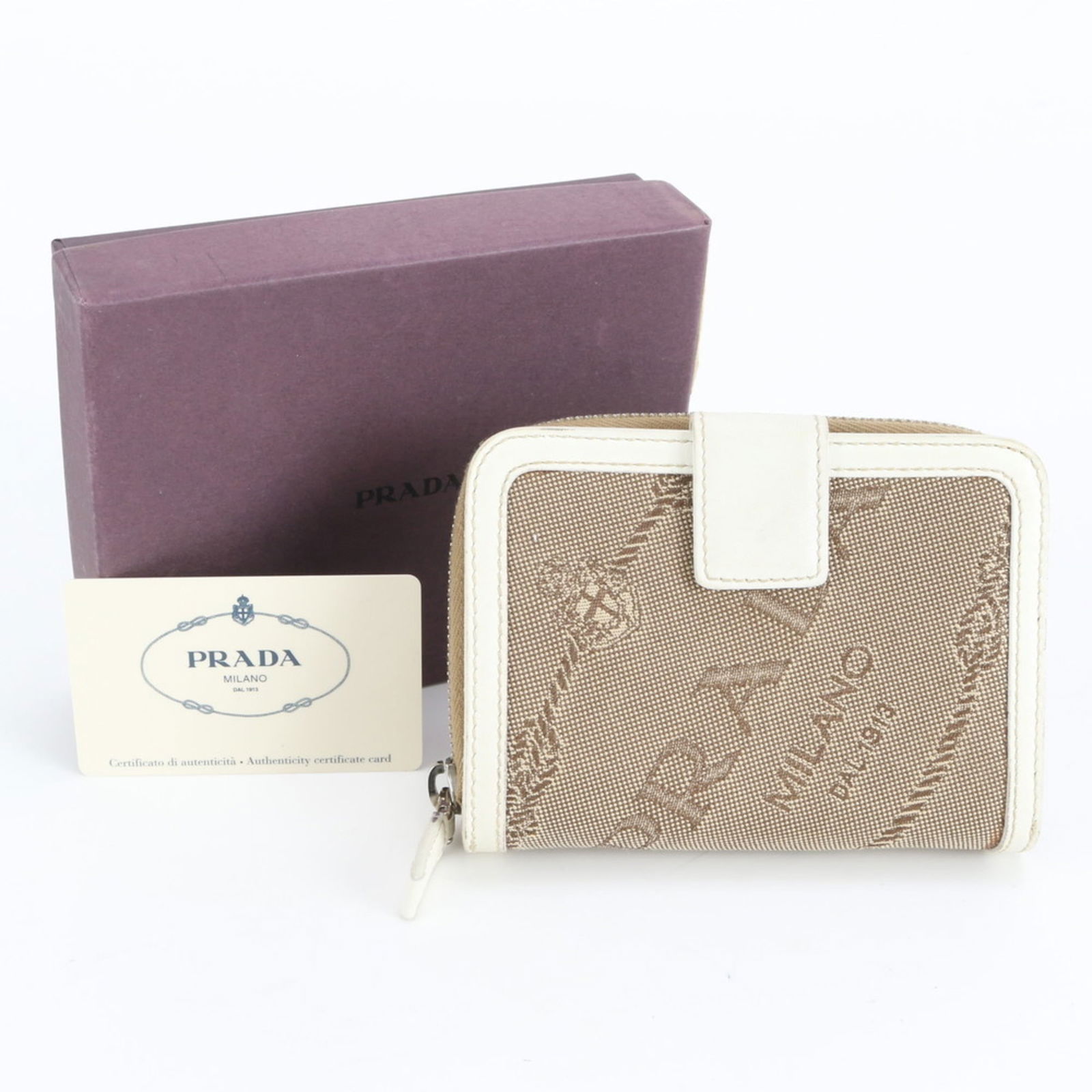 Prada Bi-Fold Leather Wallet: Prada Bi-Fold Leather Wallet A timeless piece from the iconic Italian fashion house, this Prada bi-fold leather wallet boasts sleek design and premium materials, with its classic beige and white color