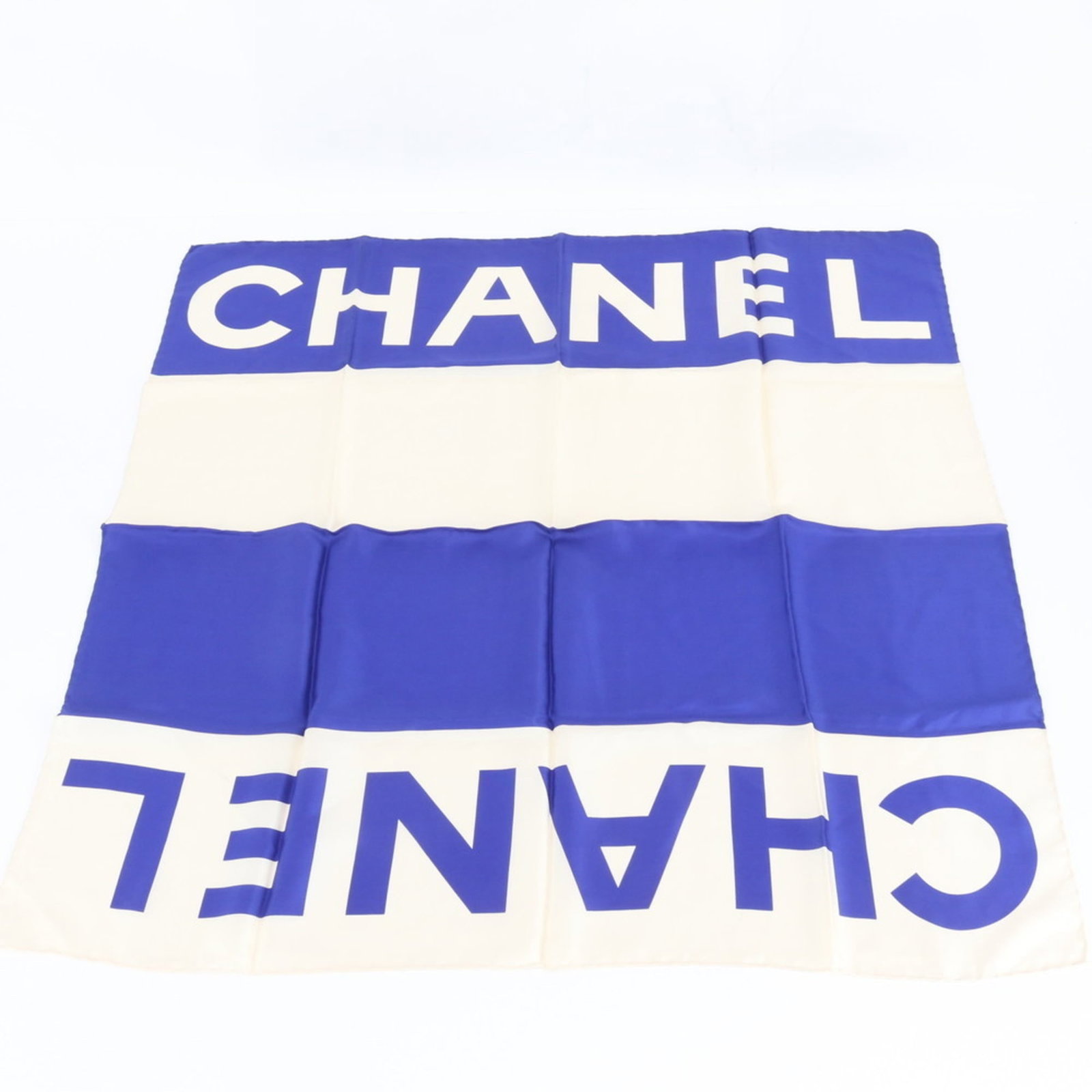 Scarf Chanel: Scarf Chanel A pre-owned Chanel scarf in exquisite beige and blue hues, boasting the iconic interlocking CC logo, adds a touch of timeless elegance to any outfit. With its soft texture and subtle shee