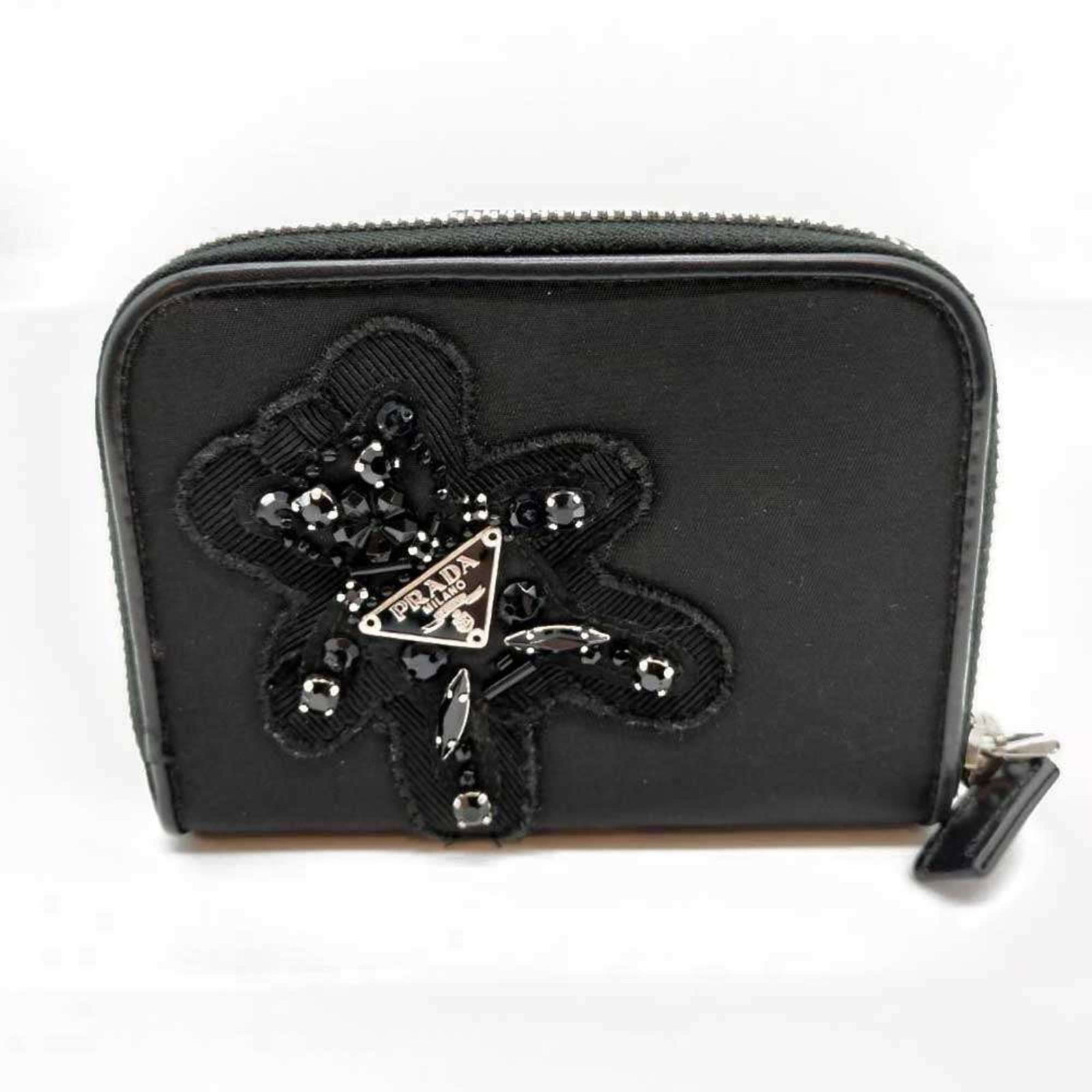 Prada Bi-Fold Nylon Wallet: Prada Bi-Fold Nylon Wallet A sleek and versatile bi-fold wallet from Prada, crafted from durable nylon with a snap closure and multiple pockets for organization. The black exterior adds a touch of sop