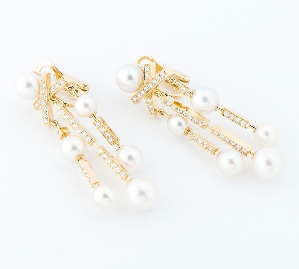 Chanel Pearl and Diamond Dangle Earring in 18k Yellow Gold: Chanel Pearl and Diamond Dangle Earring in 18k Yellow Gold Elevate your elegance with the timeless charm of Chanel's Pearl and Diamond Dangle Earring in 18k Yellow Gold. This exquisite piece boasts a