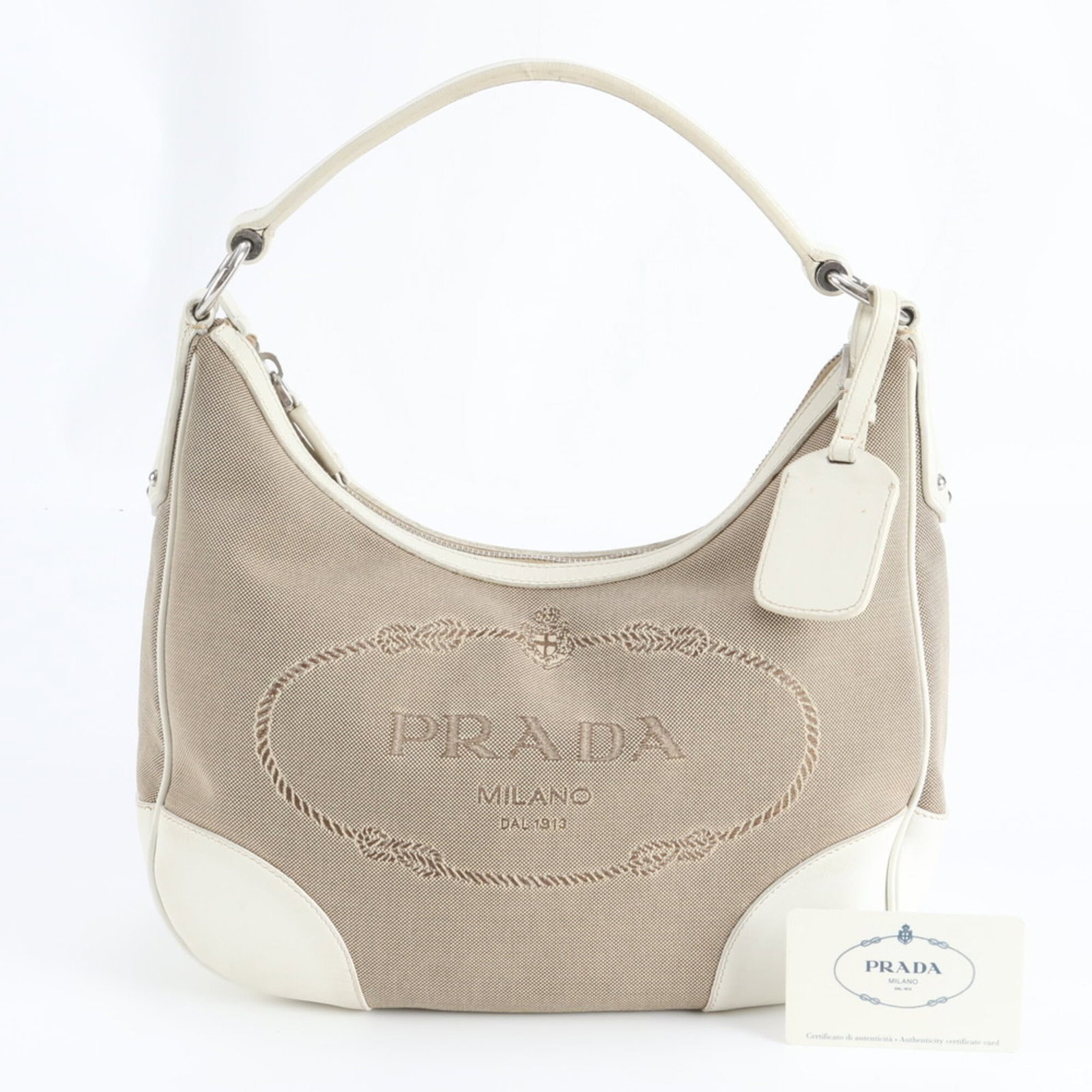 Prada Shoulder Bag Leather, Canvas: Prada Shoulder Bag Leather, Canvas A timeless Prada shoulder bag, crafted from rich leather and canvas, boasts a classic design that exudes sophistication. With its spacious interior and comfortable