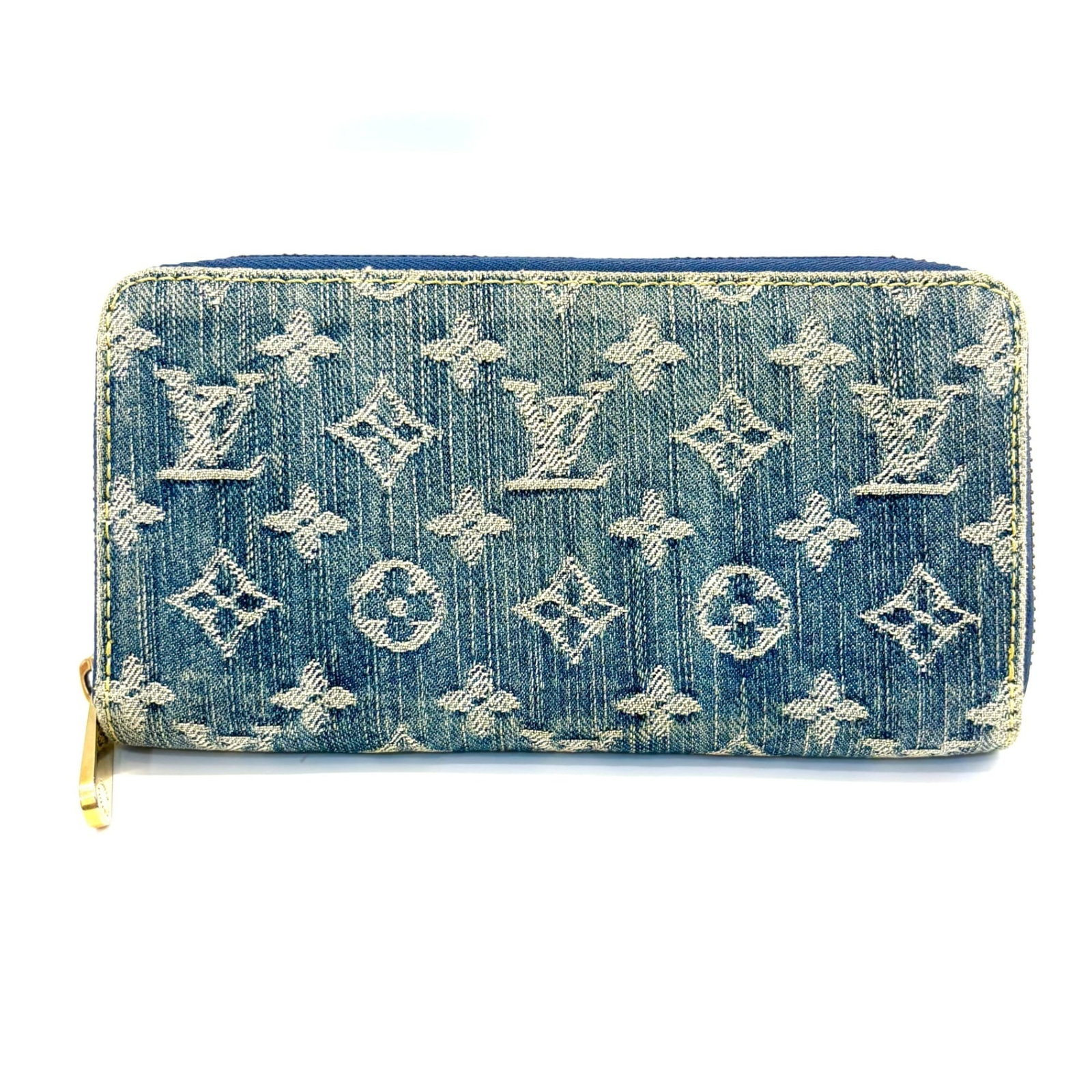 Louis Vuitton Long Bi Fold Monogram Denim: Louis Vuitton Long Bi Fold Monogram Denim A rare find for the Louis Vuitton enthusiast, this vintage Long Bi Fold Monogram Denim wallet boasts the iconic brand's signature monogram pattern in rich