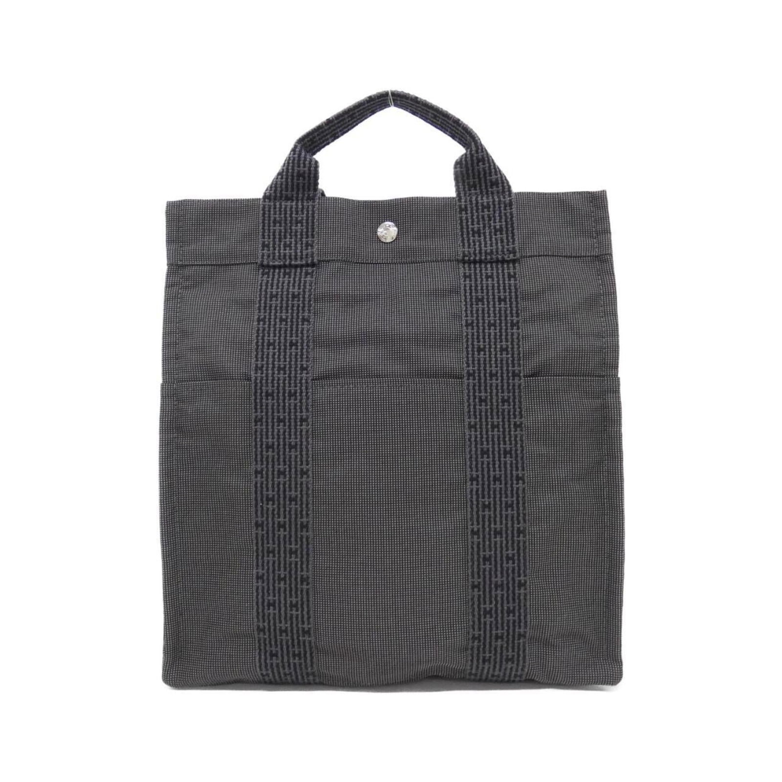 Hermes Canvas Backpack: Hermes Canvas Backpack A timeless and stylish addition to any woman's wardrobe, this pre-owned Hermes canvas backpack boasts classic design with a sleek black finish. With its spacious interior and du