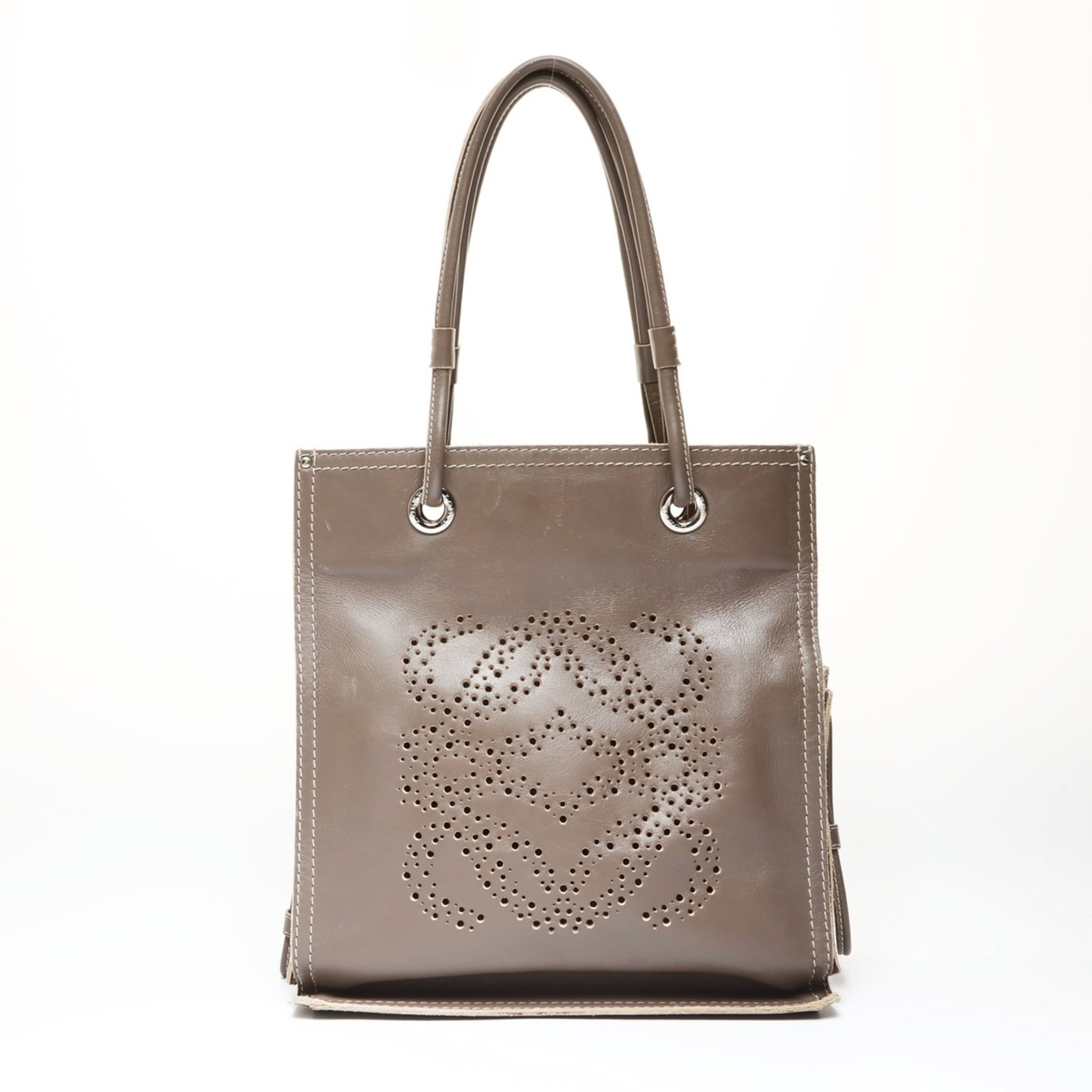 Loewe Tote Bag Leather: Loewe Tote Bag Leather A pre-owned Loewe tote bag in rich gray brown leather, boasting the iconic brand's signature craftsmanship and timeless design. With its spacious interior and adjustable handle