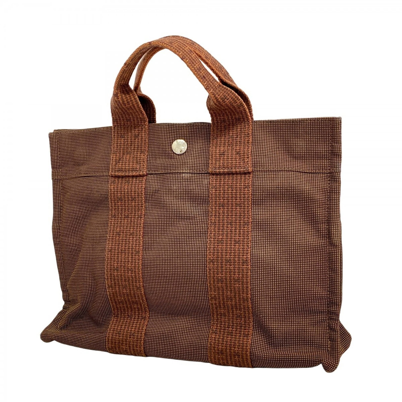 Hermes Tote Bag Canvas: Hermes Tote Bag Canvas A pre-owned Hermes tote bag canvas in rich brown leather, adorned with sleek silver hardware, is now available. With its classic 24.5cm x 31cm size and comfortable 8cm depth,