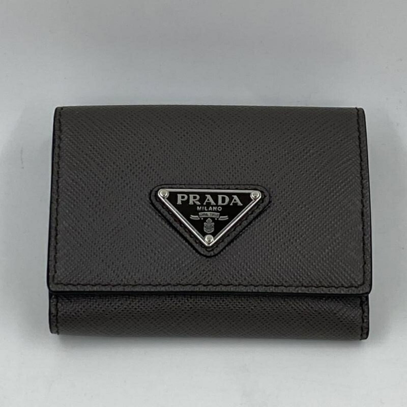 Prada Wallet (Tri-Fold) Leather: Prada Wallet (Tri-Fold) Leather A stylish and functional Prada tri-fold wallet, this green leather accessory is perfect for adding a touch of sophistication to your daily routine. With its classic