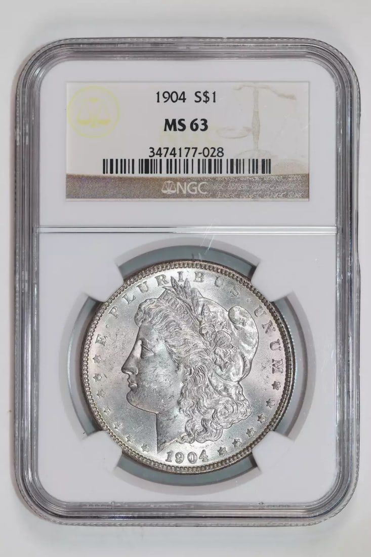 1904 MORGAN DOLLAR NGC MS63: 1904 MORGAN DOLLAR NGC MS63 Experience the beauty of American numismatics with this stunning 1904 Morgan Dollar, certified MS63 by the Numismatic Guaranty Corporation (NGC). Struck from silver and boa