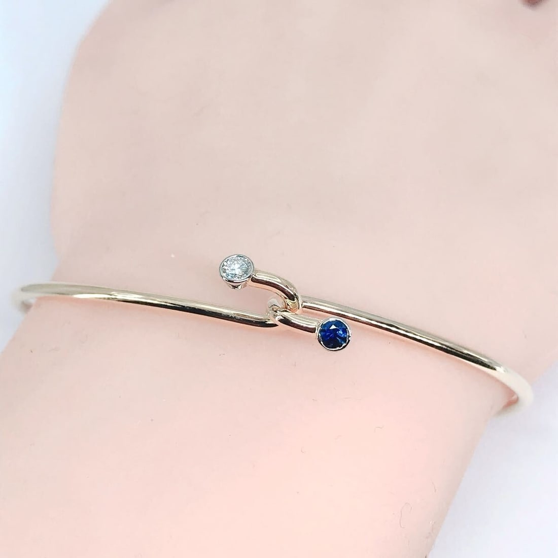 Vintage Tiffany & Co Diamond Sapphire Wire Hook 14k Yellow Gold Bangle Bracelet: Vintage Tiffany & Co Diamond Sapphire Wire Hook 14k Yellow Gold Bangle Bracelet Elegantly crafted in 14k yellow gold, this vintage Tiffany & Co bangle boasts two precious stones: a round diamond and